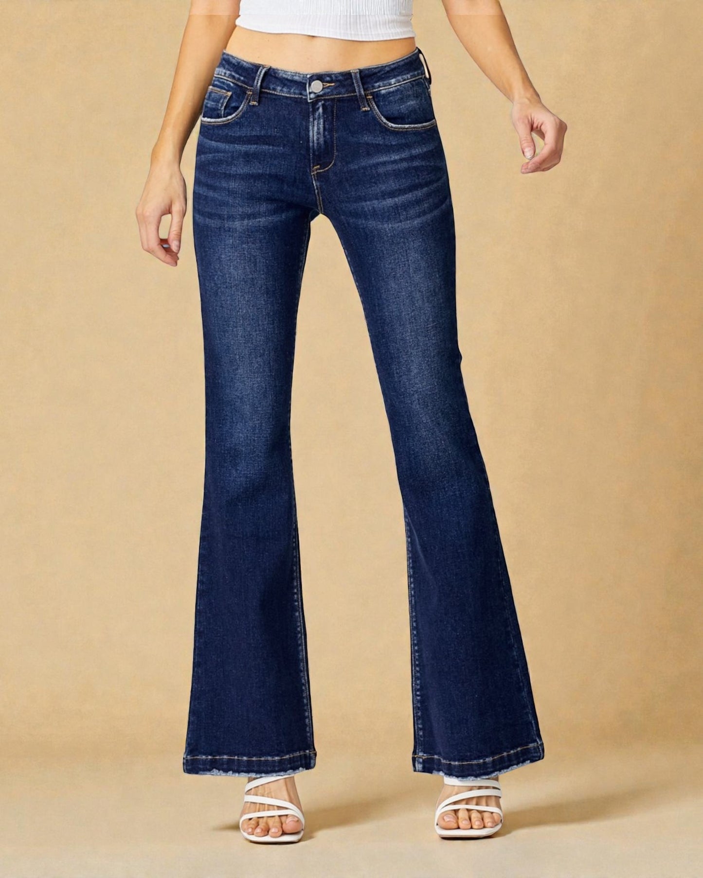 Flared jeans worn by a person on a beige background