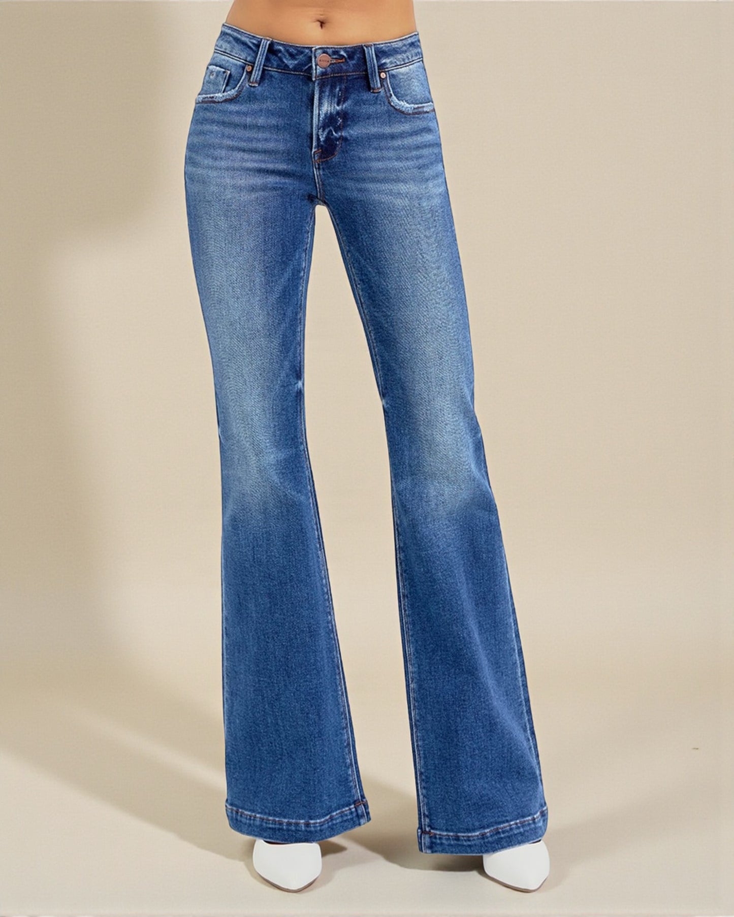Blue flared jeans on a beige background