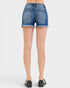 Blue denim shorts worn by a person on a white background