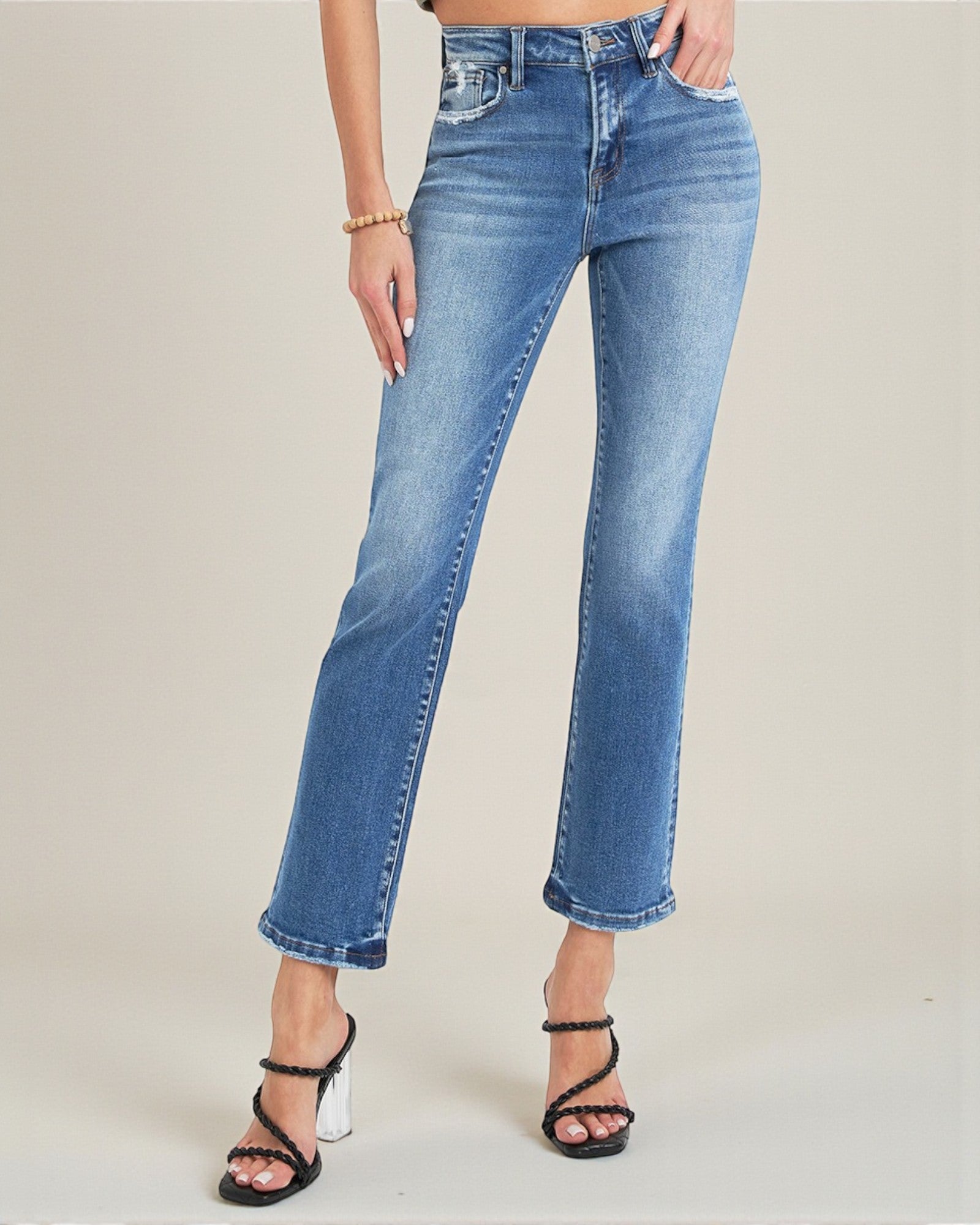 Person wearing blue jeans on a plain background