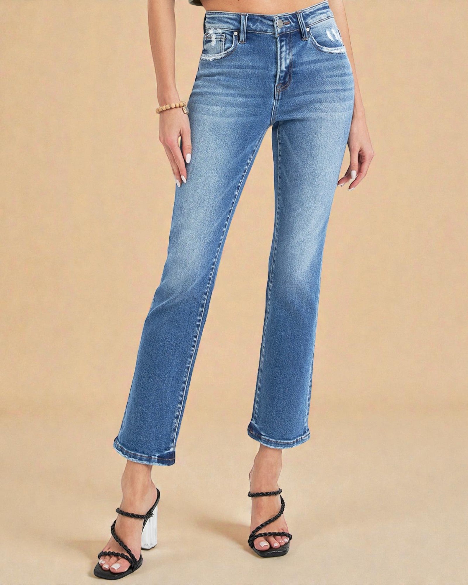Person wearing blue jeans on a beige background