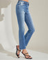 Blue jeans worn by a person on a plain background