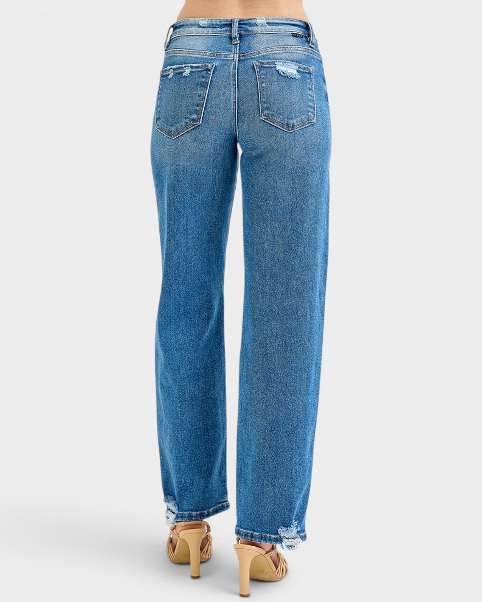 Blue jeans worn by a person on a white background