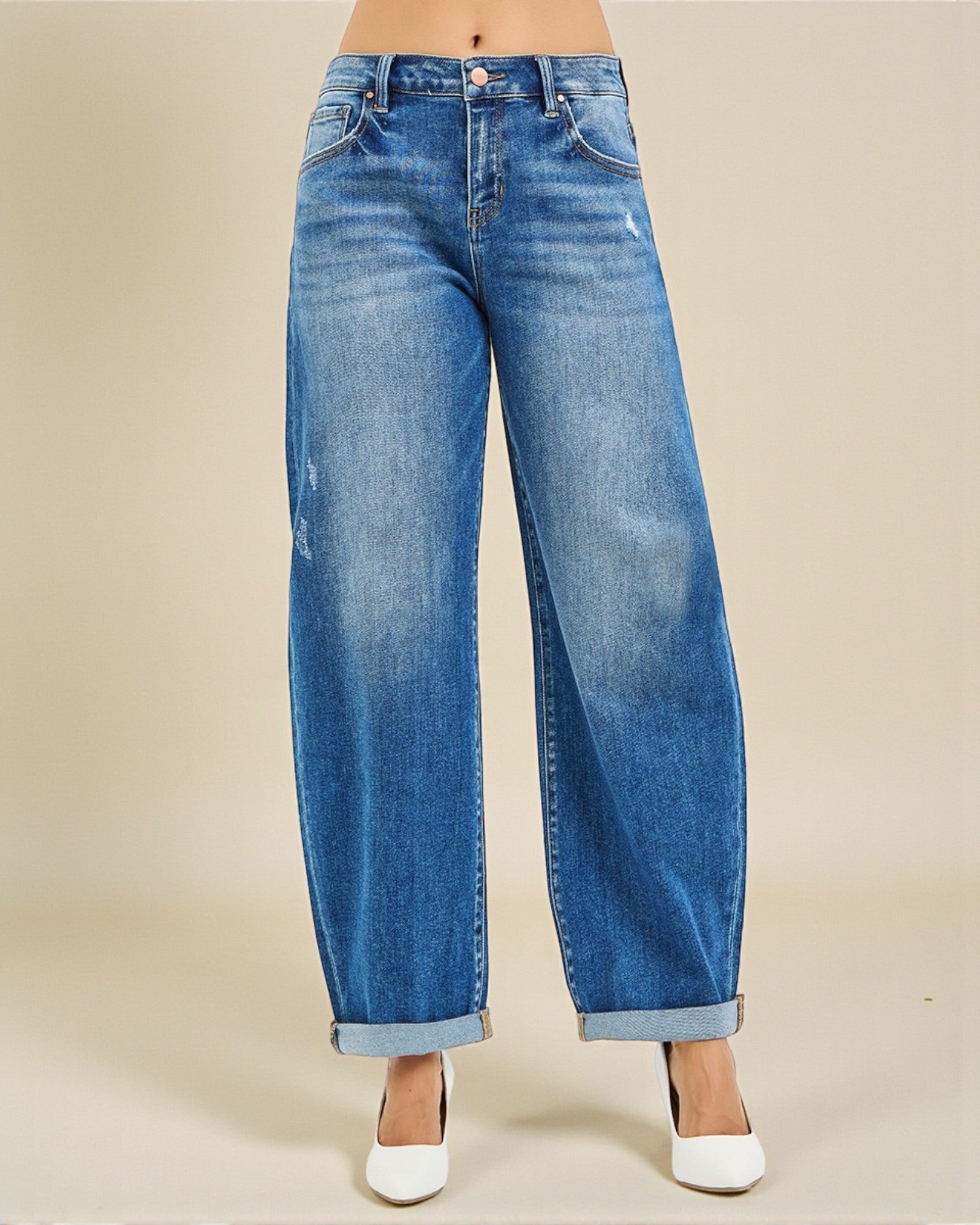 Blue jeans worn by a person on a beige background