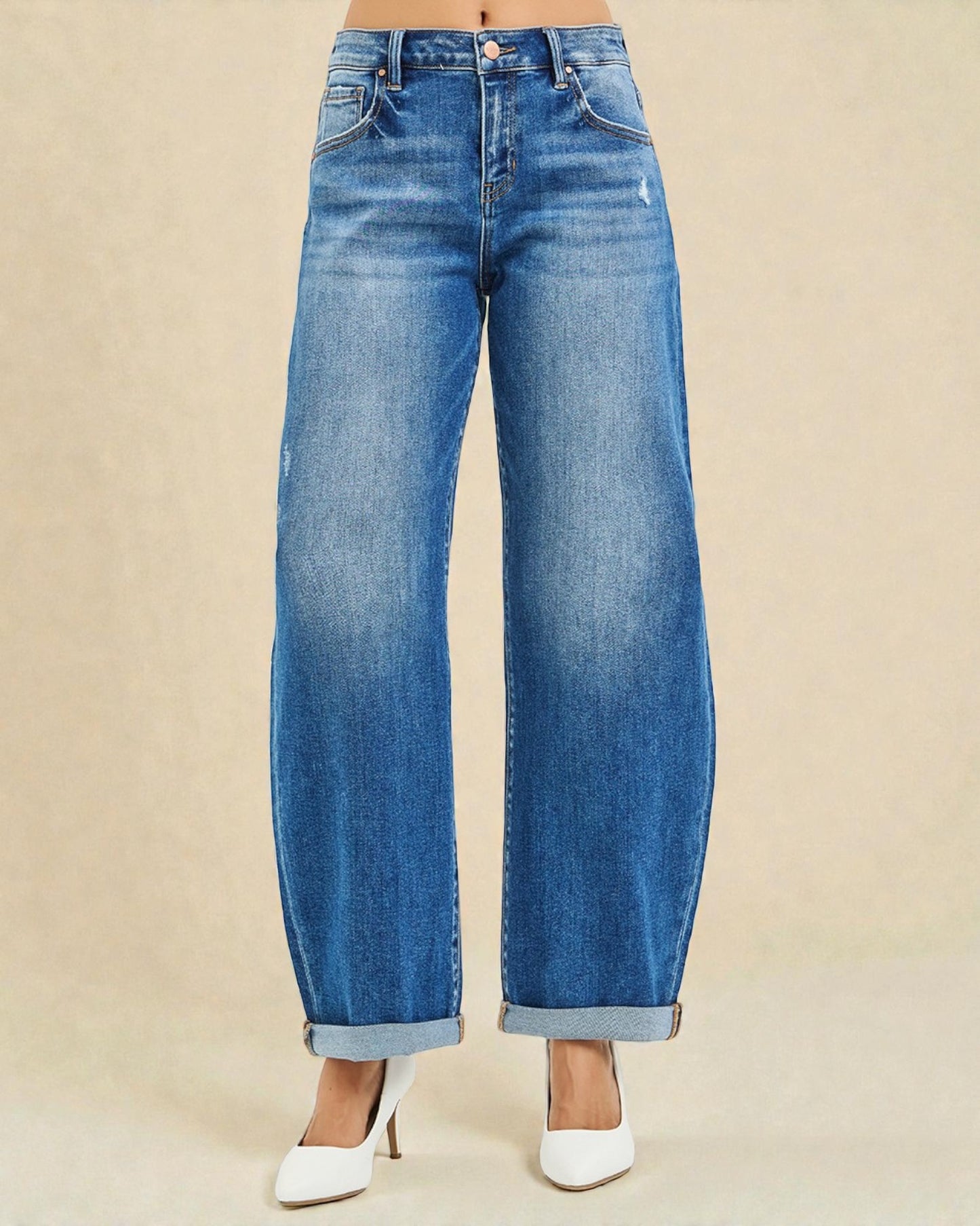 Blue jeans worn by a person on a beige background