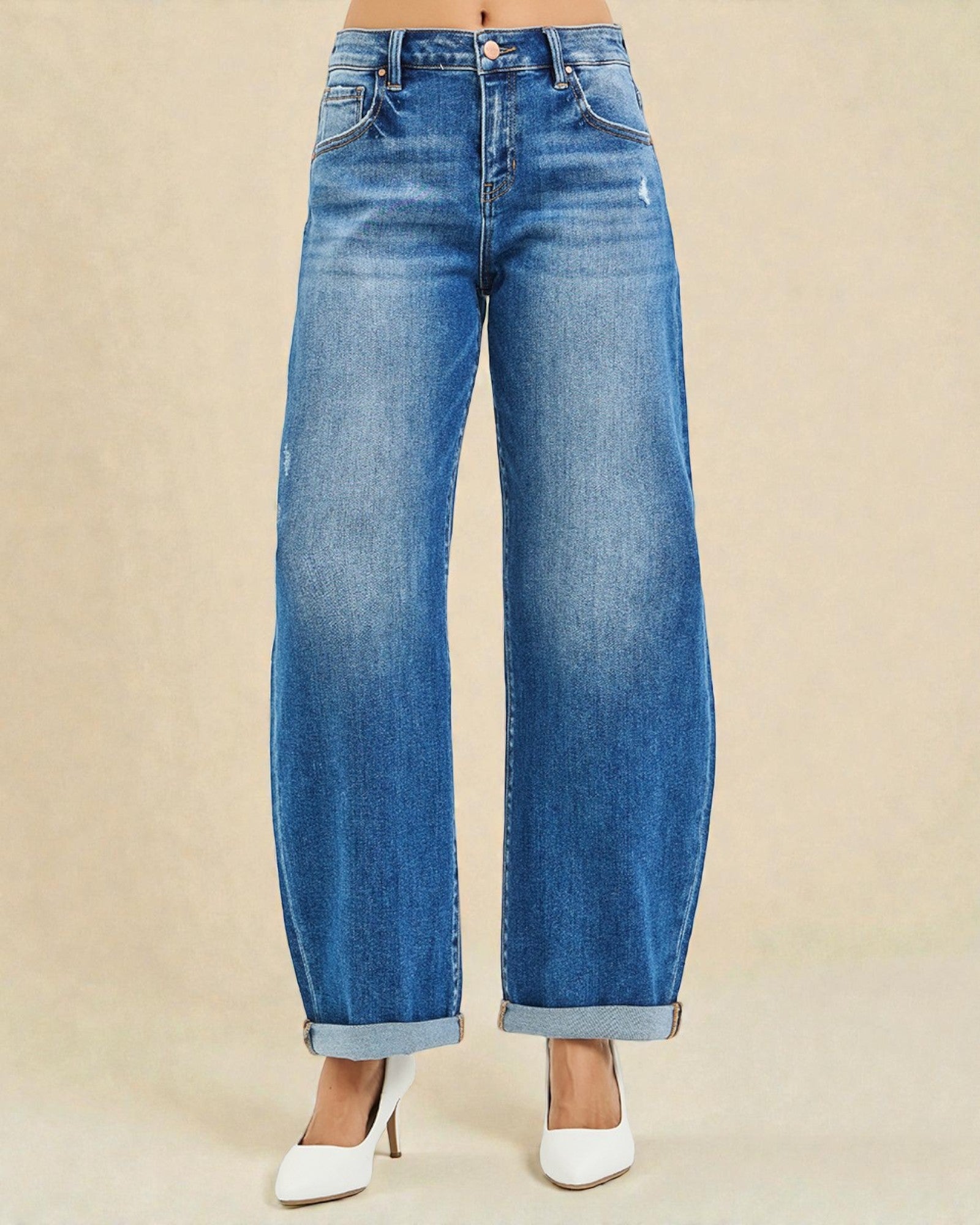 Blue jeans worn by a person on a beige background