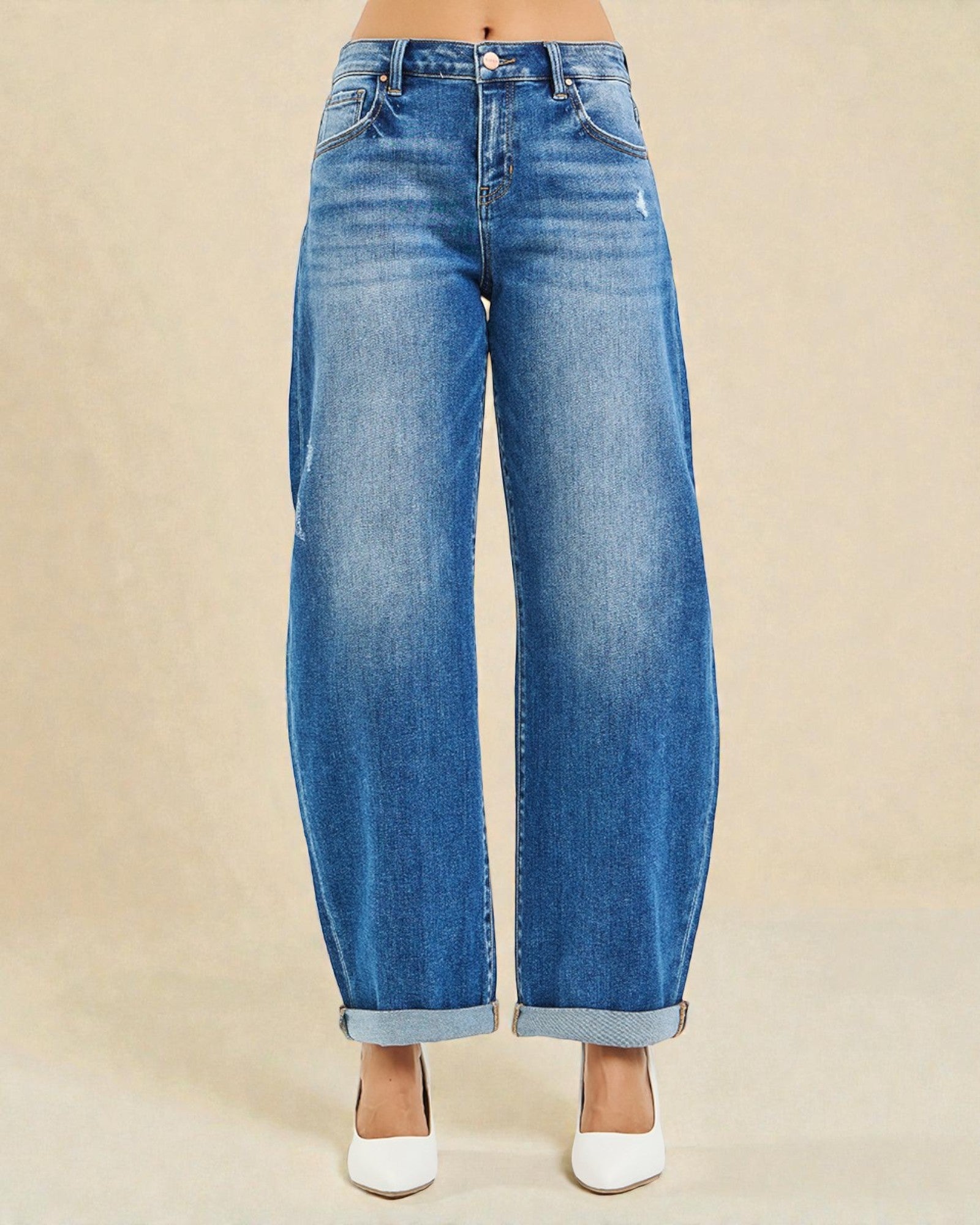 Blue jeans worn by a person on a beige background