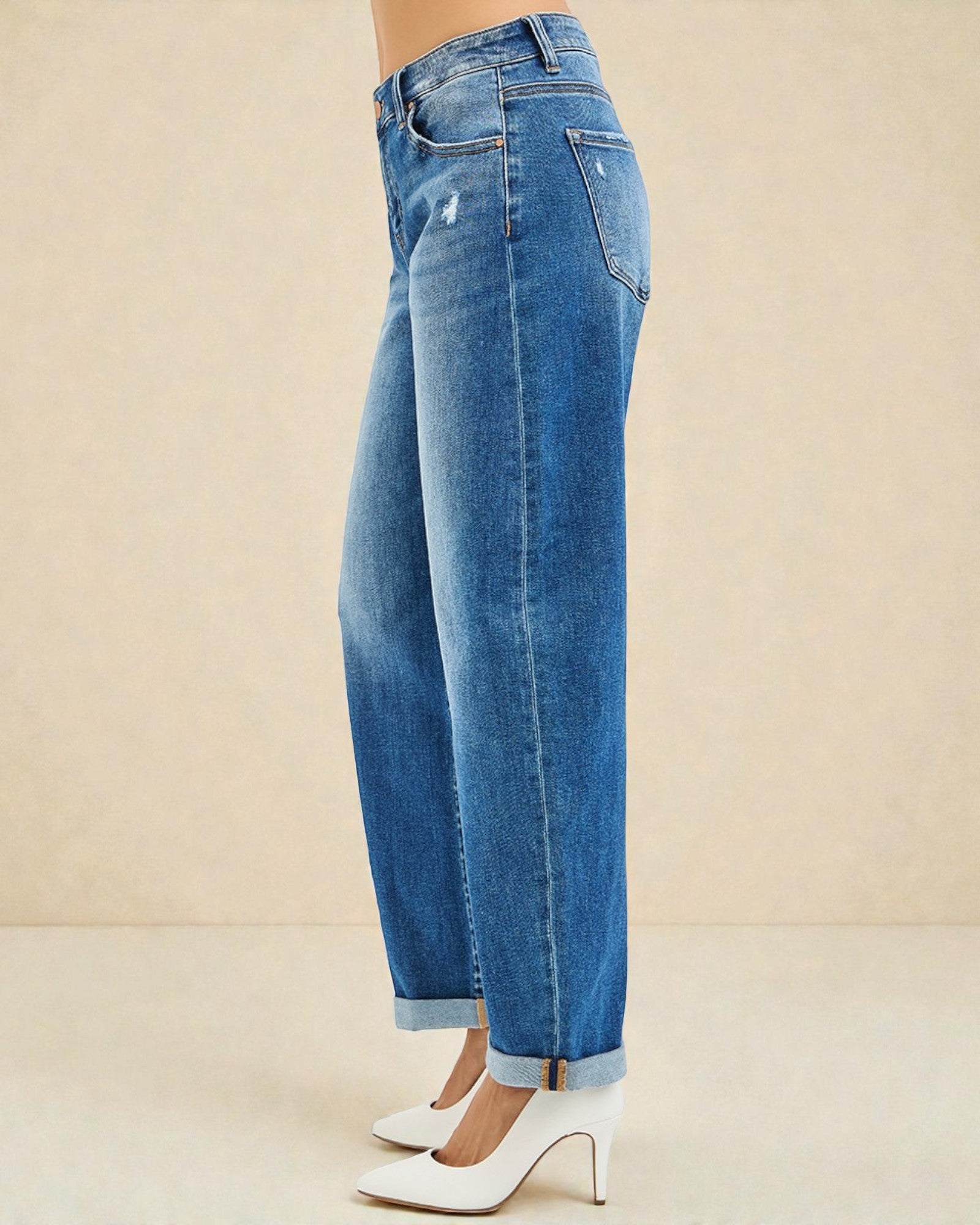 Blue jeans worn by a person on a beige background