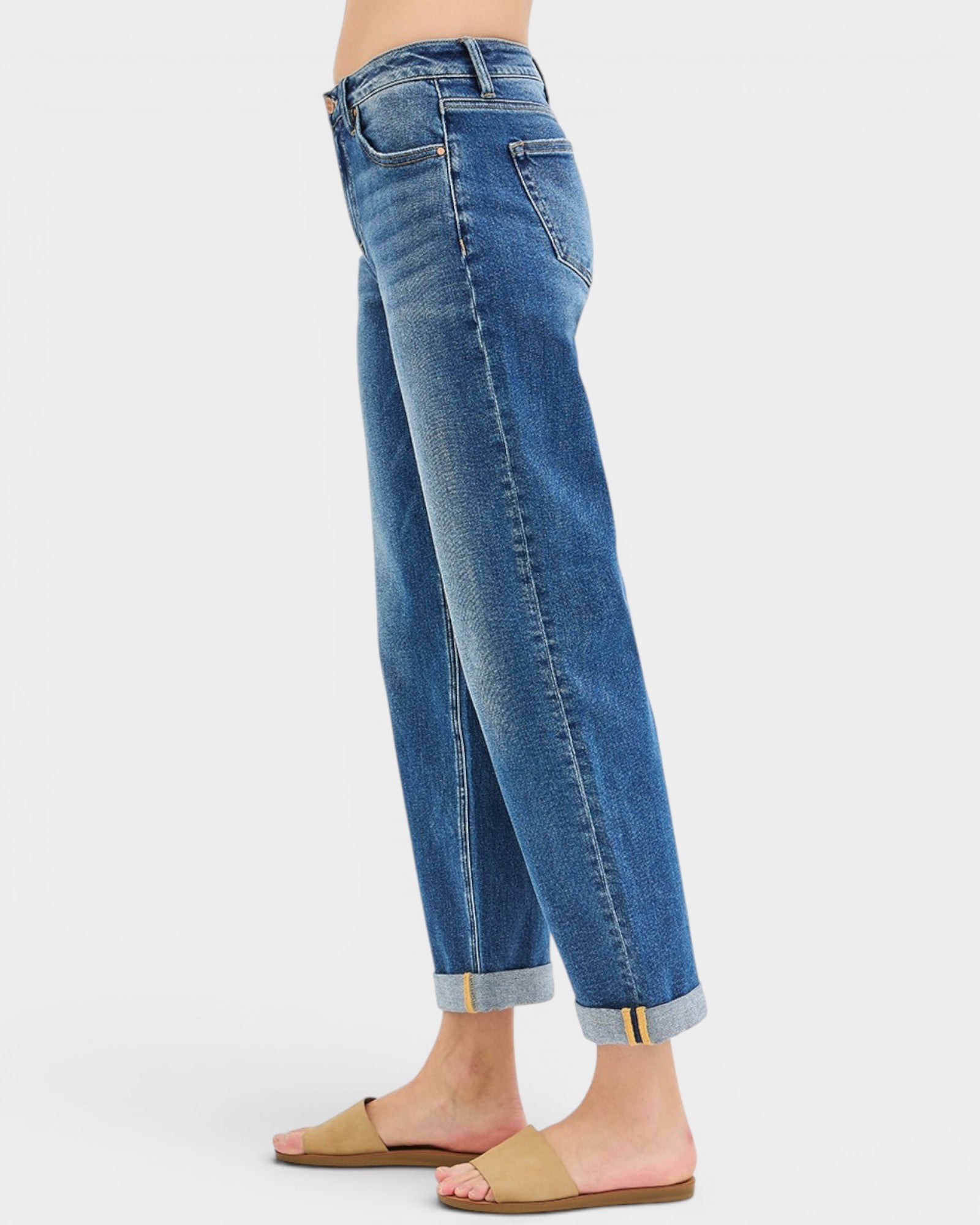 Blue jeans worn by a person on a white background