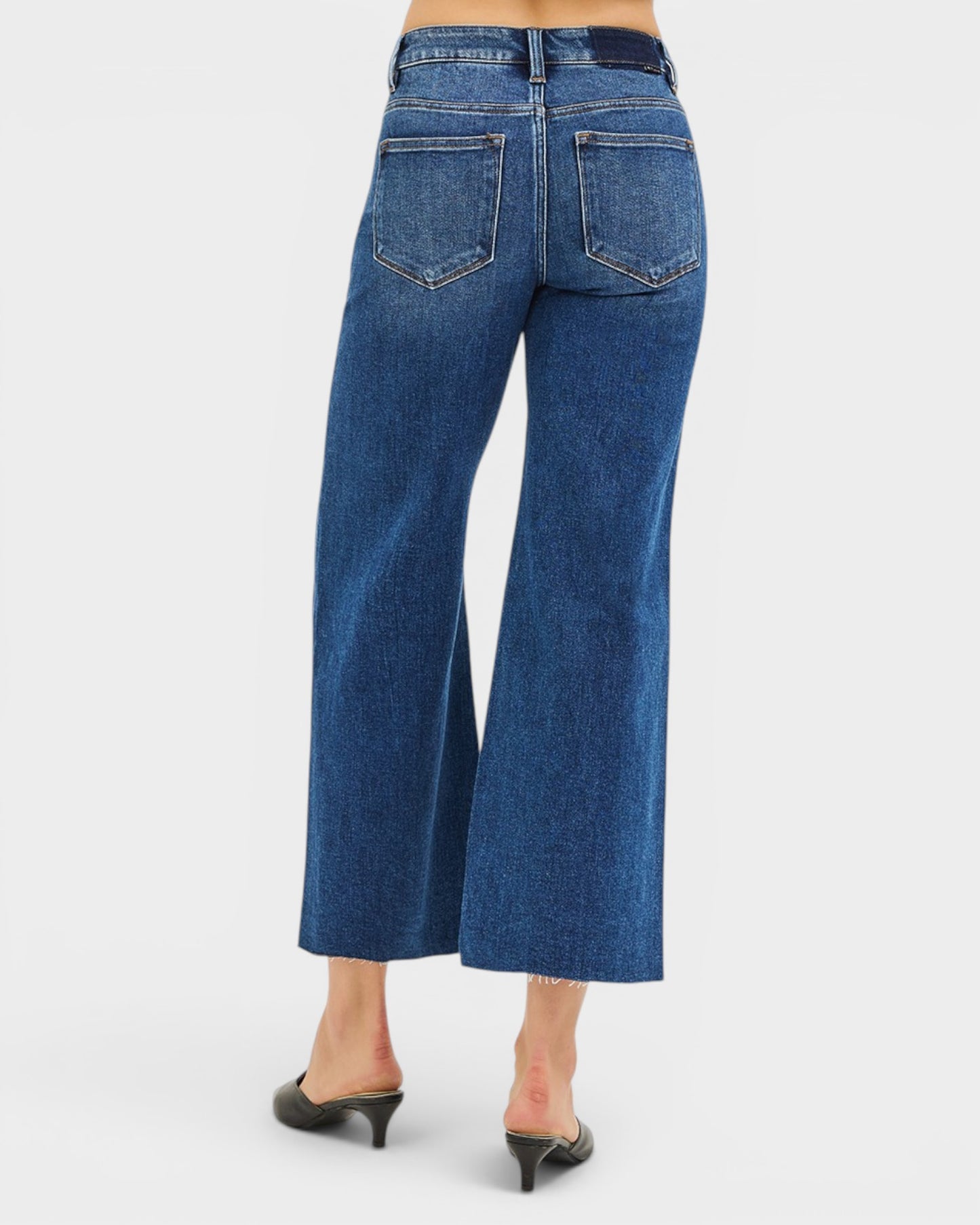 Blue jeans worn by a person on a white background