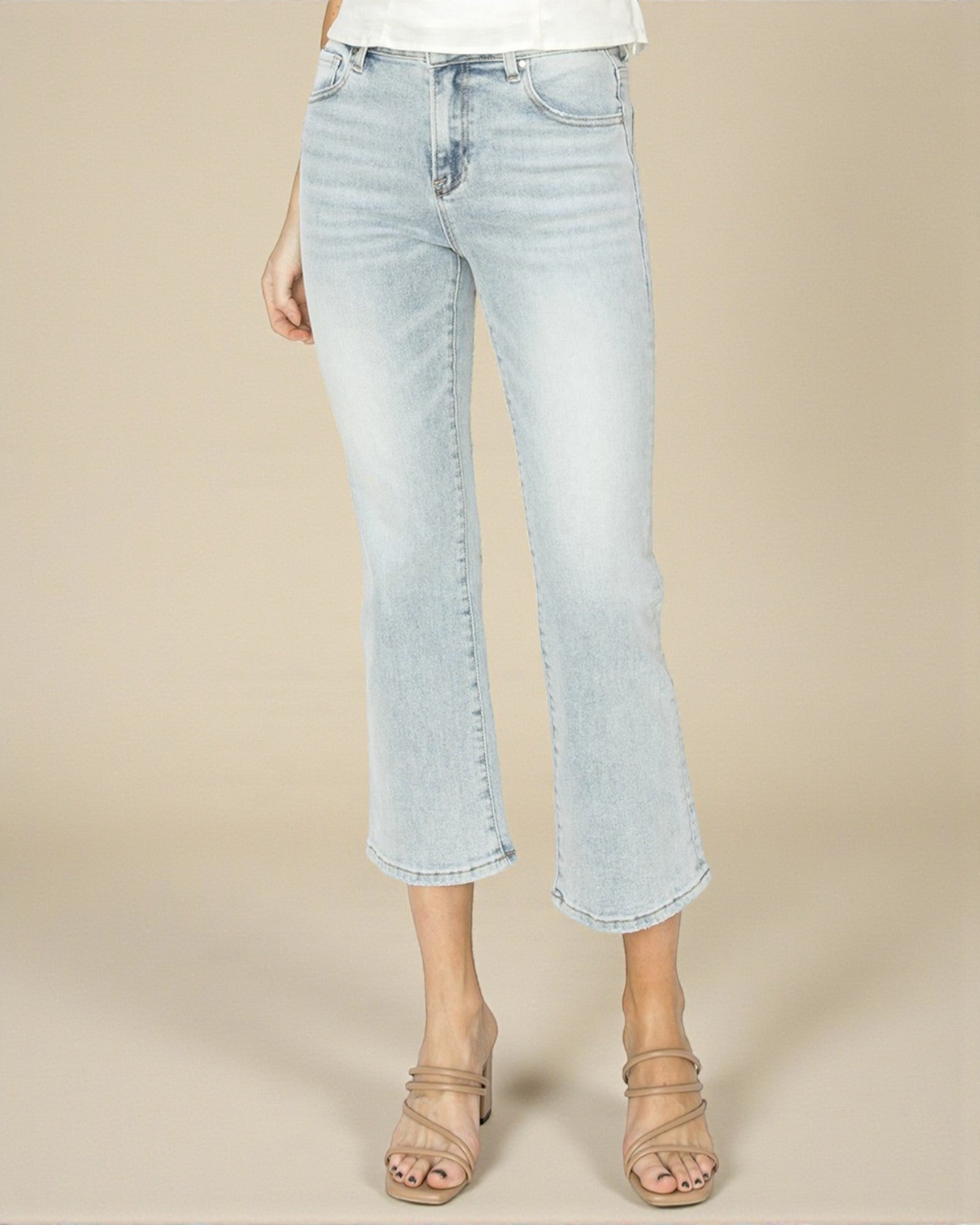Light blue jeans worn by a person on a beige background