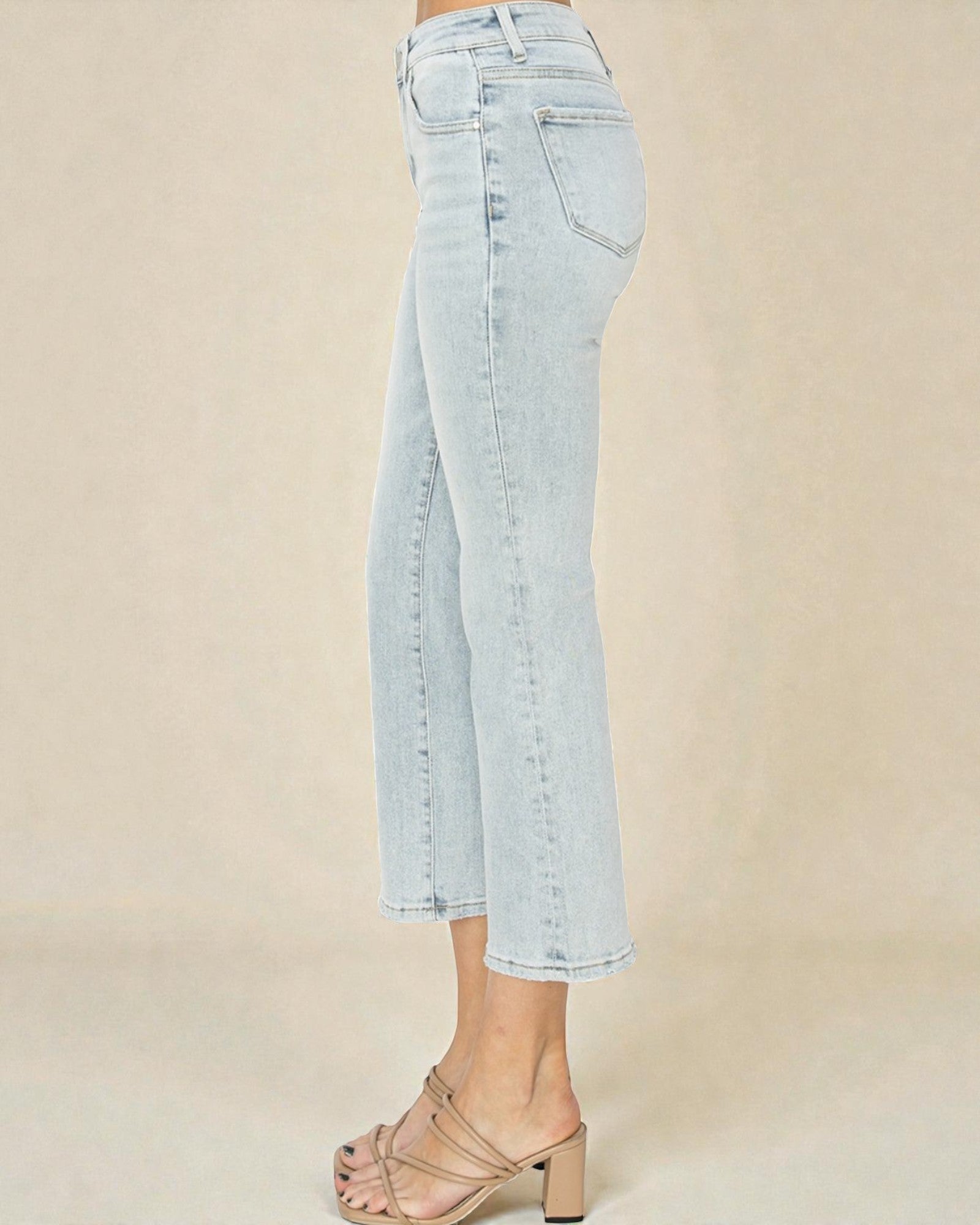 Light blue jeans worn by a person on a beige background