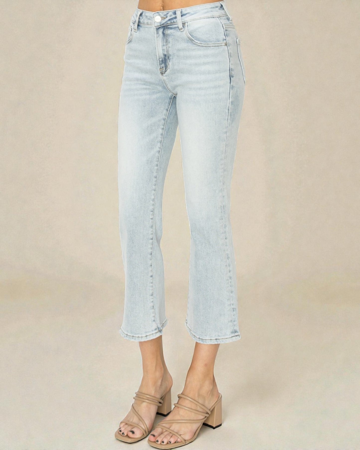 Light blue jeans worn by a person on a beige background