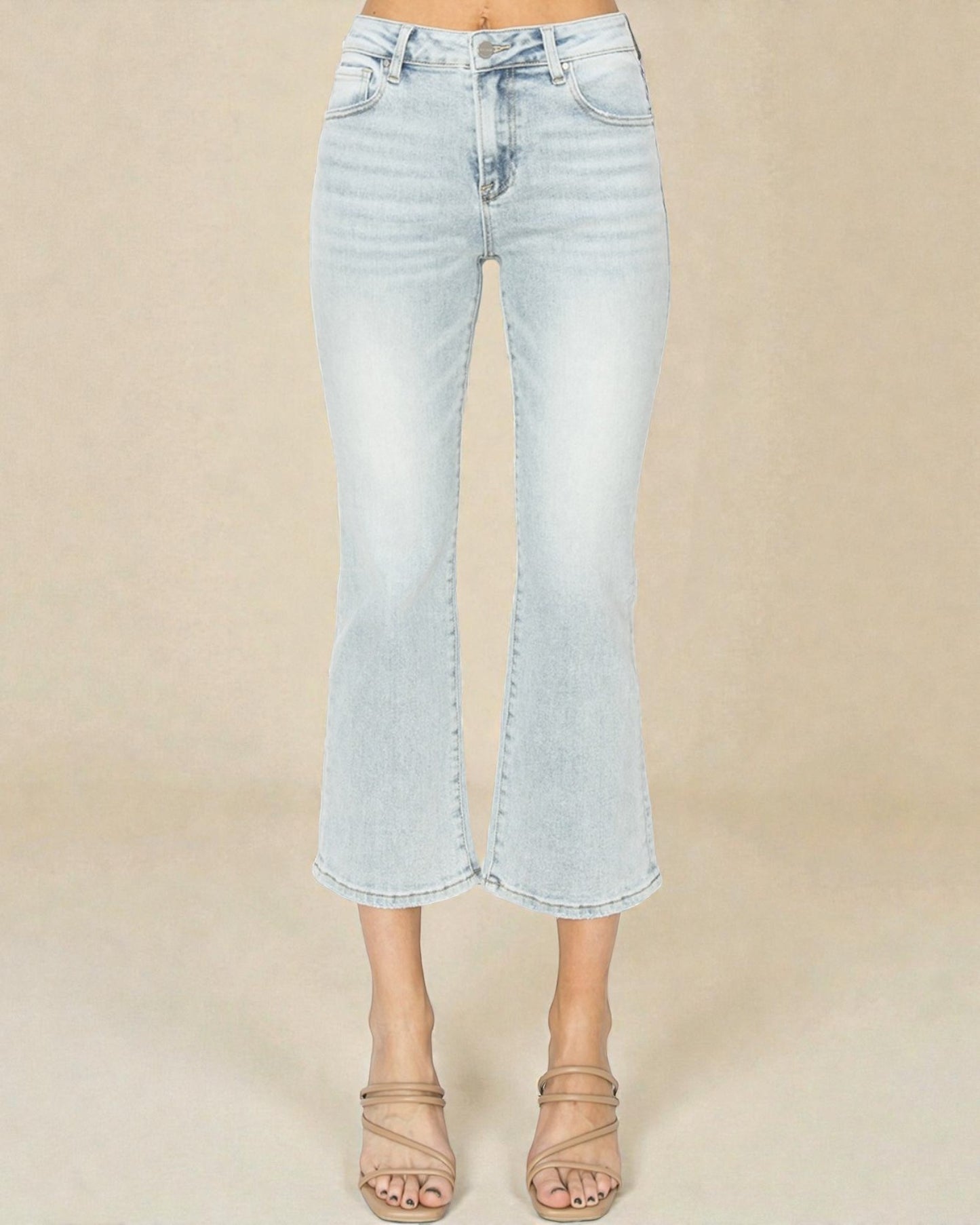 Light blue jeans worn by a person on a beige background