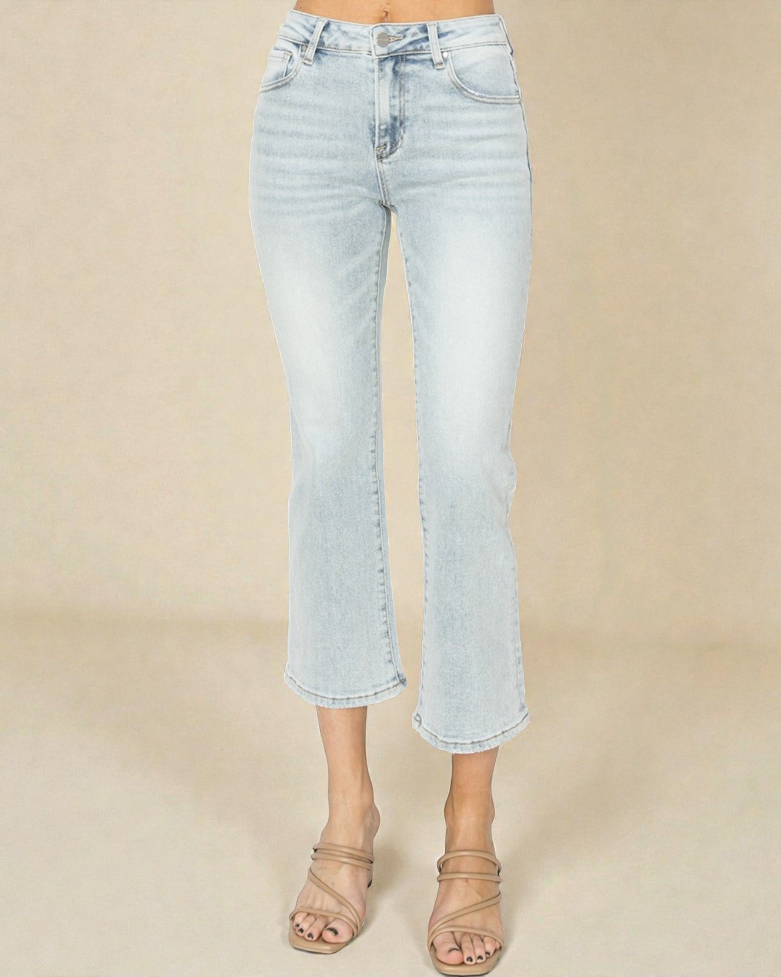 Light blue jeans worn by a person on a beige background