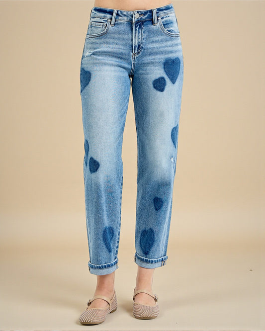 Light blue jeans with heart patterns on a beige background