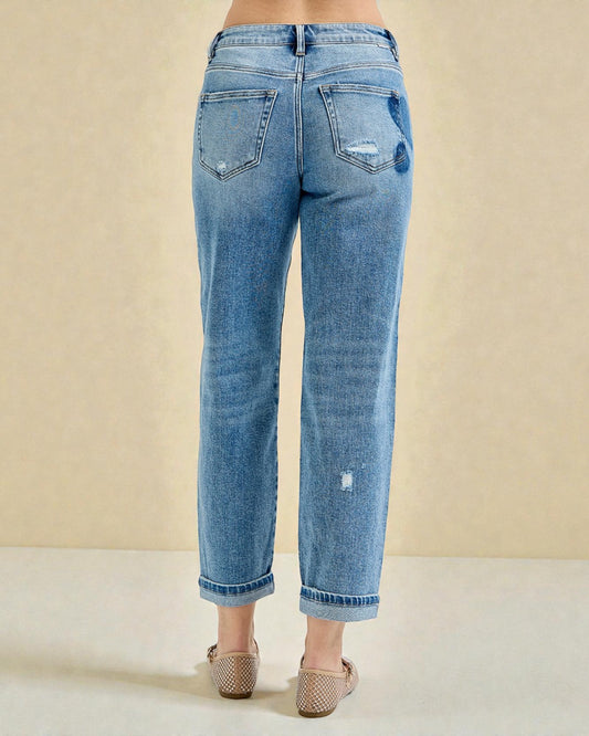 Blue jeans worn by a person on a beige background