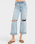 Light blue distressed jeans worn by a person on a white background