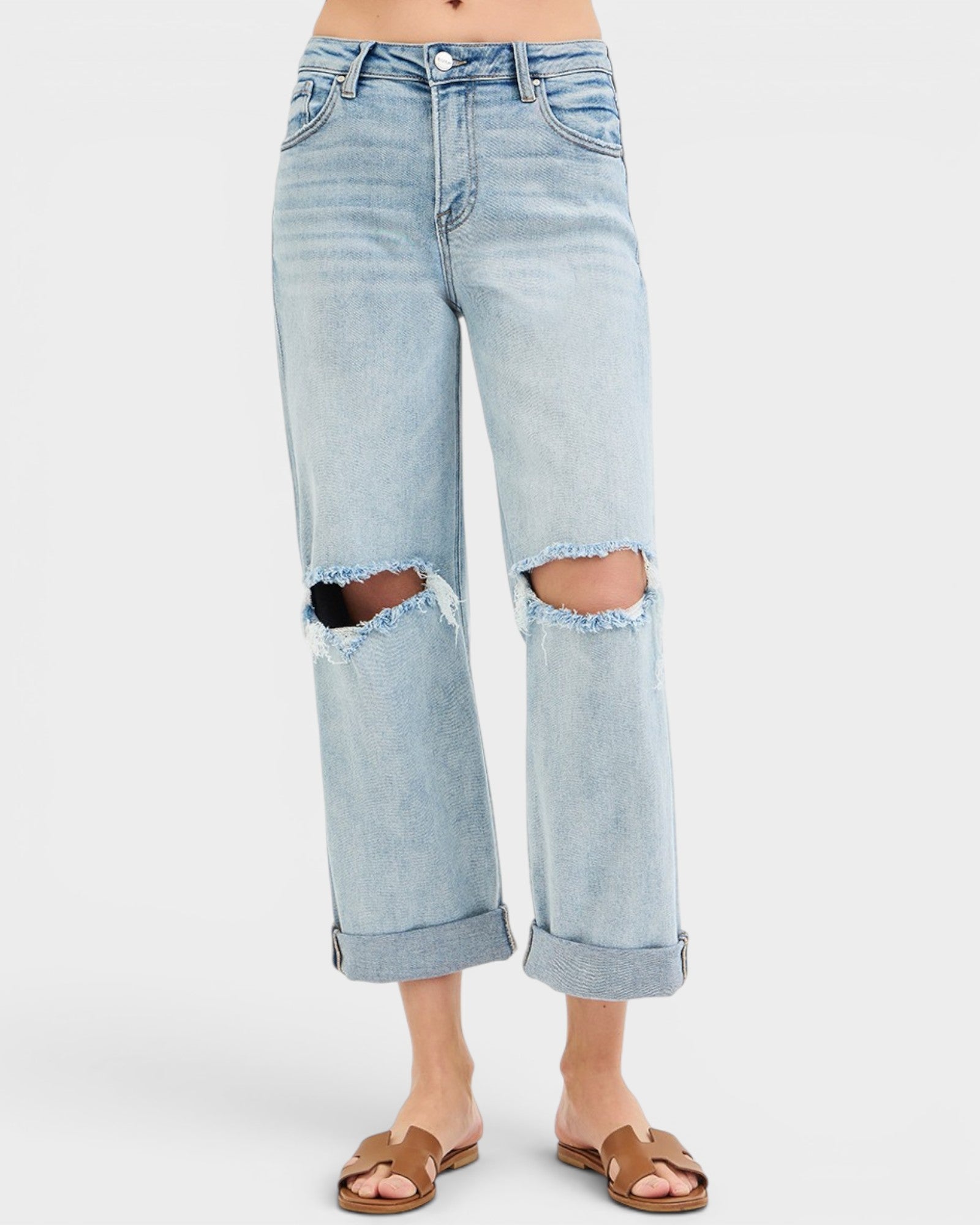 Light blue distressed jeans worn by a person on a white background