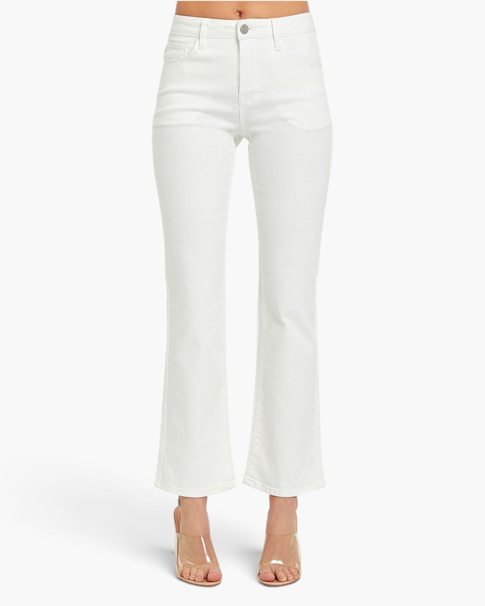 White high-waisted flared jeans shown on a model from the waist down, paired with clear strap high-heeled sandals against a plain white studio background.