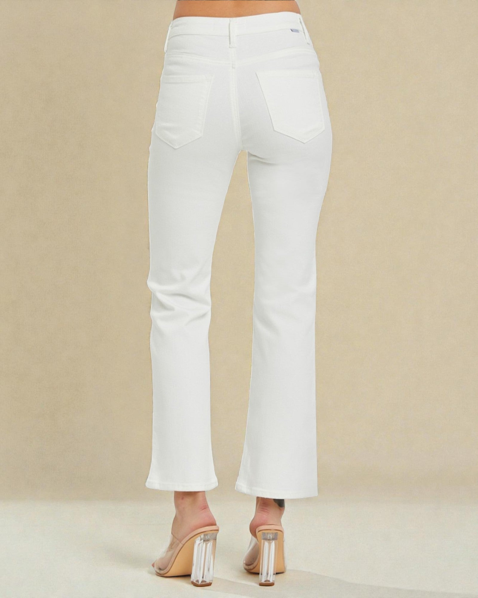 White pants worn by a person on a beige background