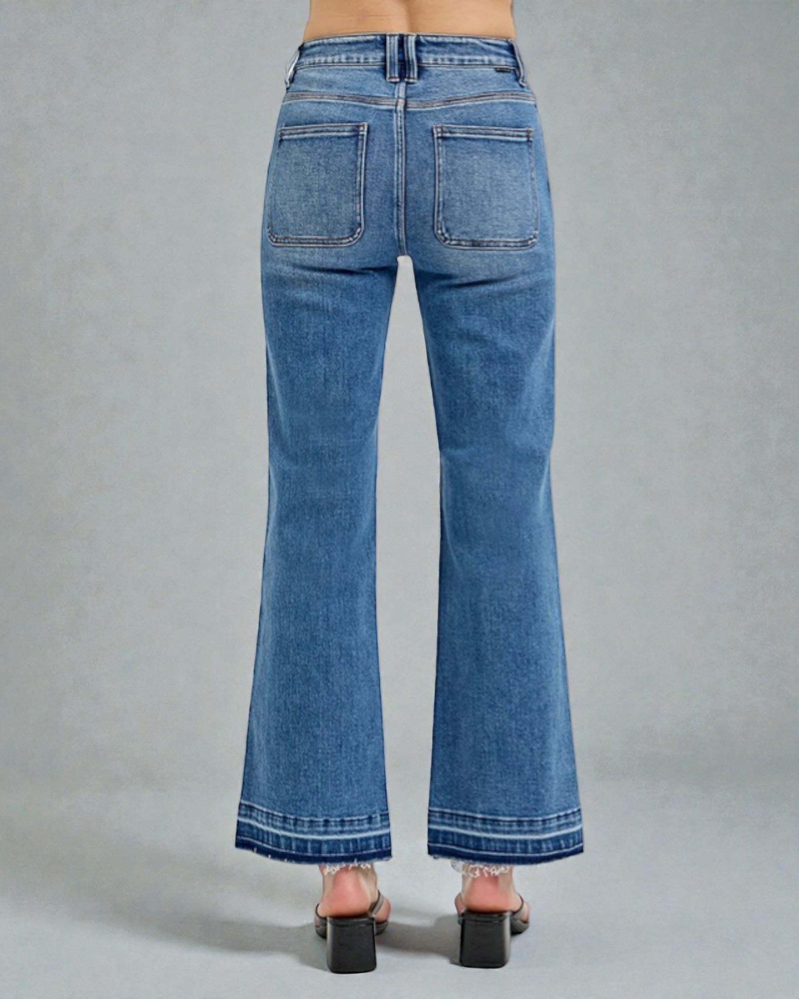 Blue jeans worn by a person on a gray background
