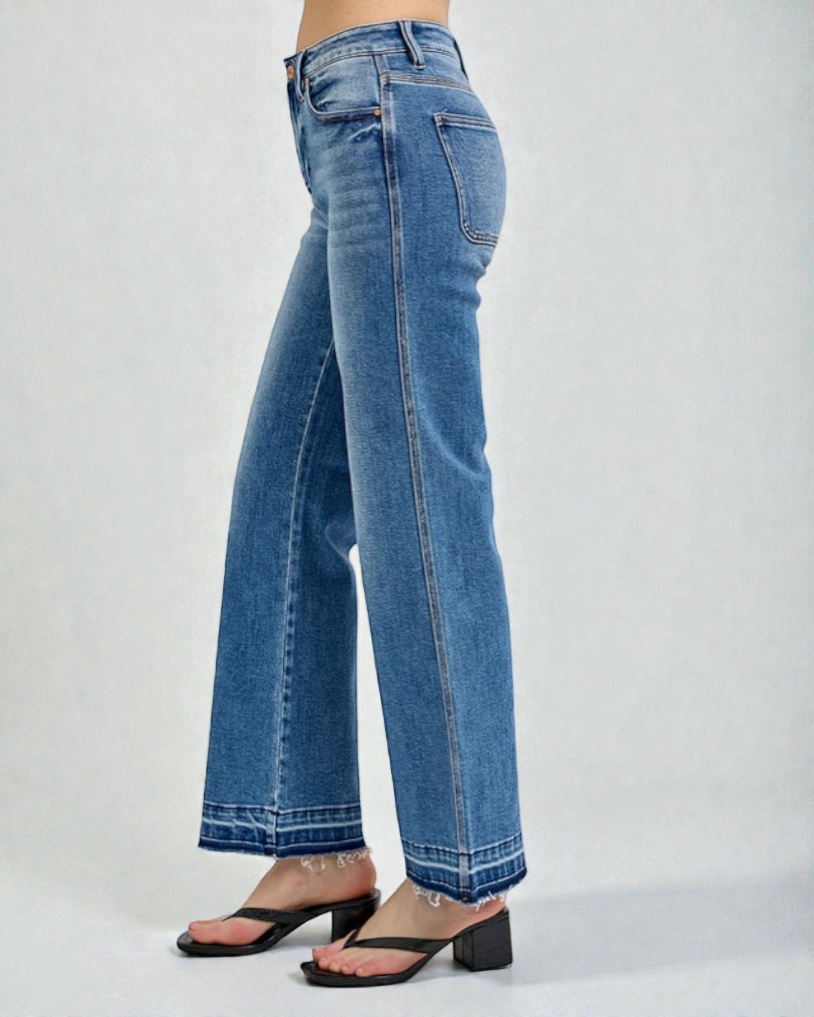 Blue jeans worn by a person on a white background