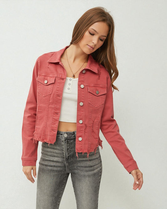 Woman wearing a pink denim jacket and gray jeans on a white background