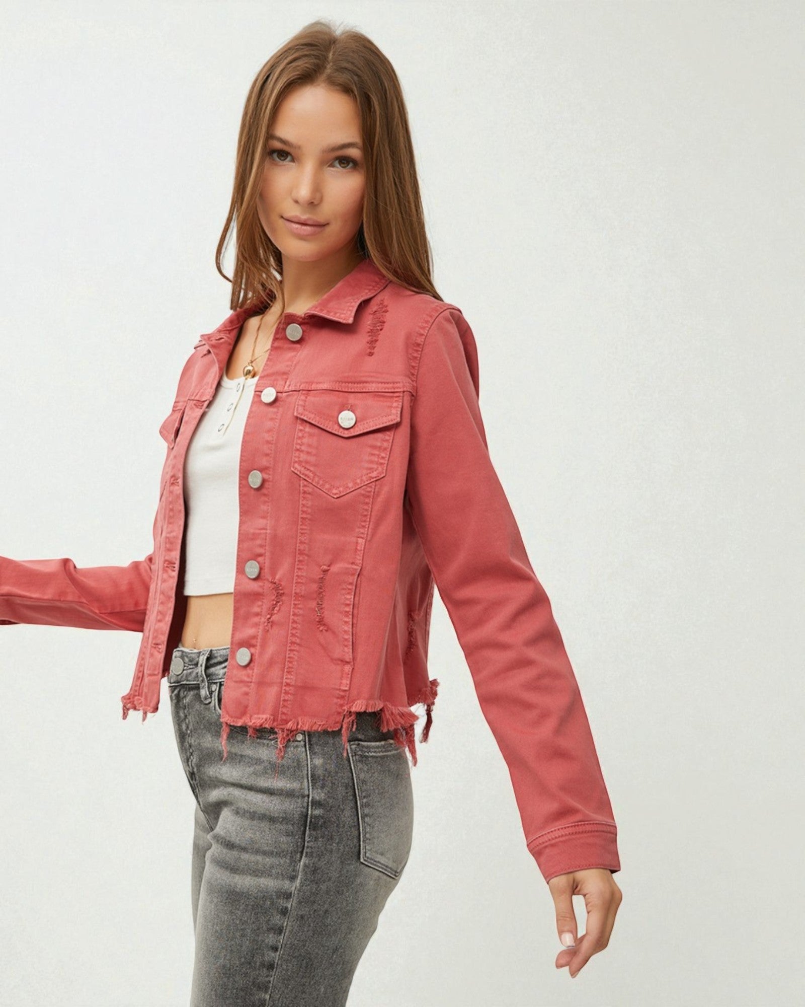 Woman wearing a pink denim jacket on a white background