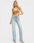 Woman wearing a brown lace top and light blue jeans on a white background