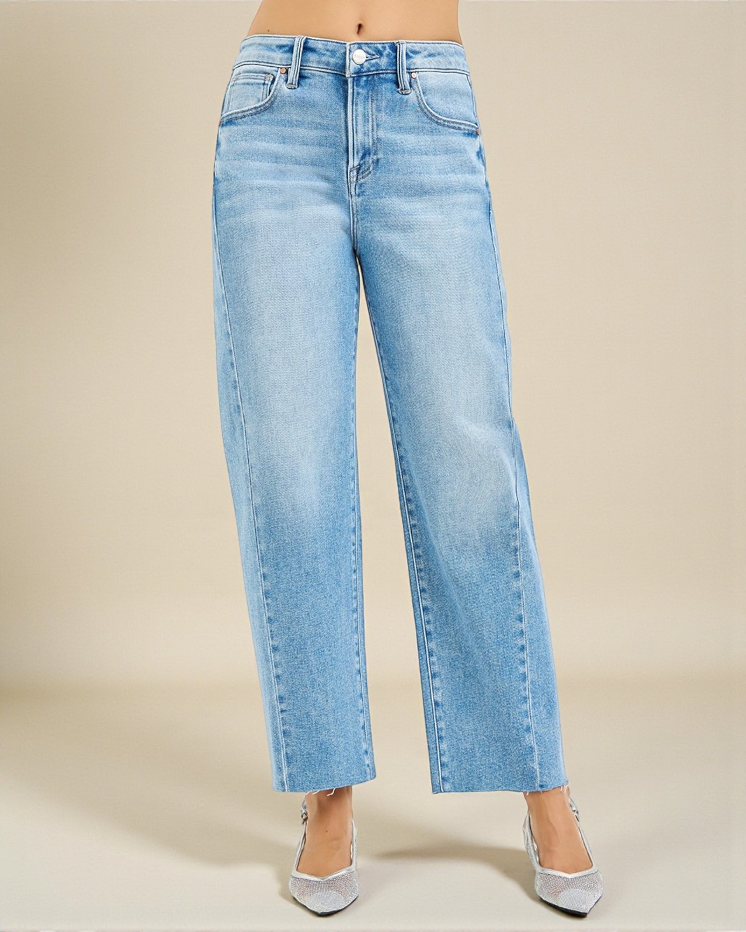 Light blue jeans worn by a person on a beige background