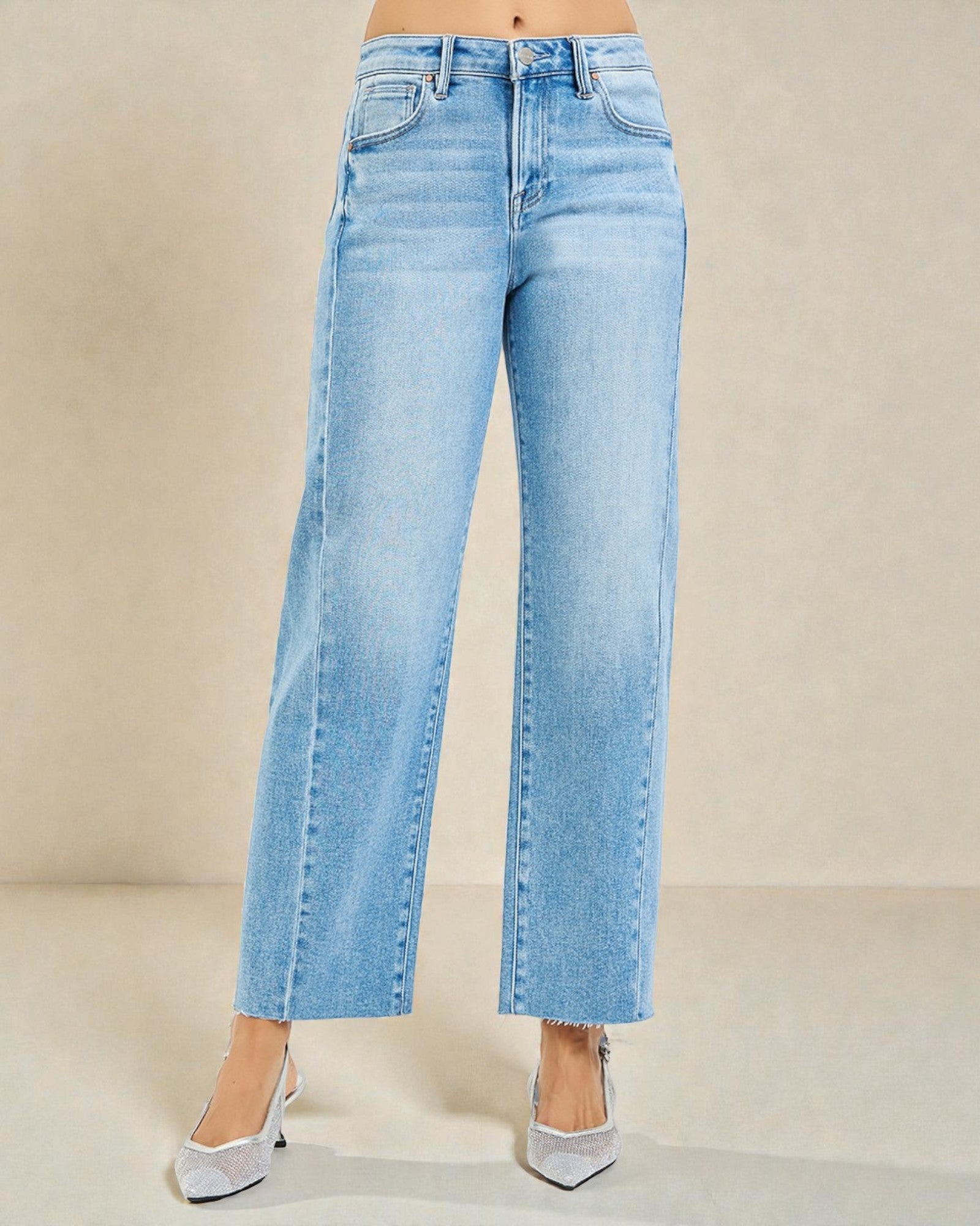 Light blue jeans worn by a person on a beige background