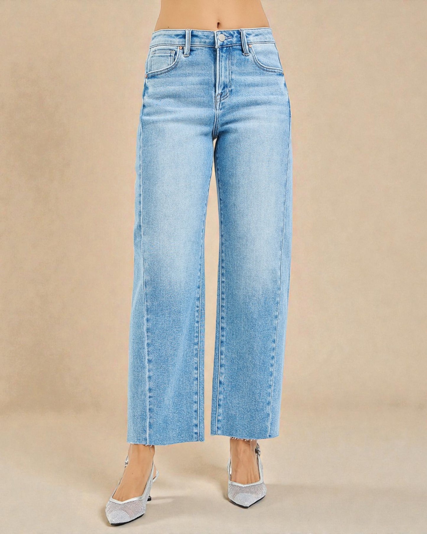 Light blue jeans worn by a person on a beige background