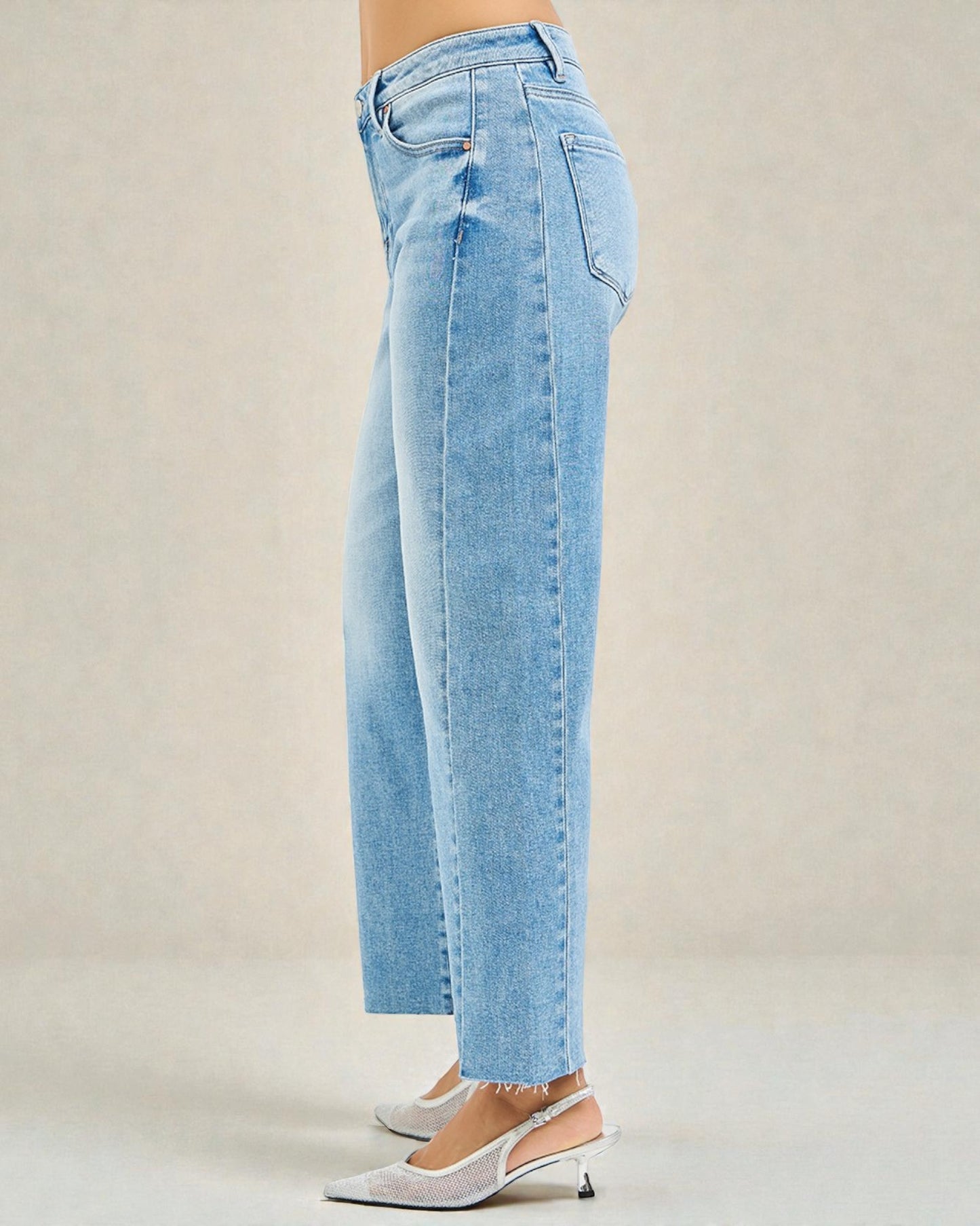 Light blue jeans worn by a person on a beige background