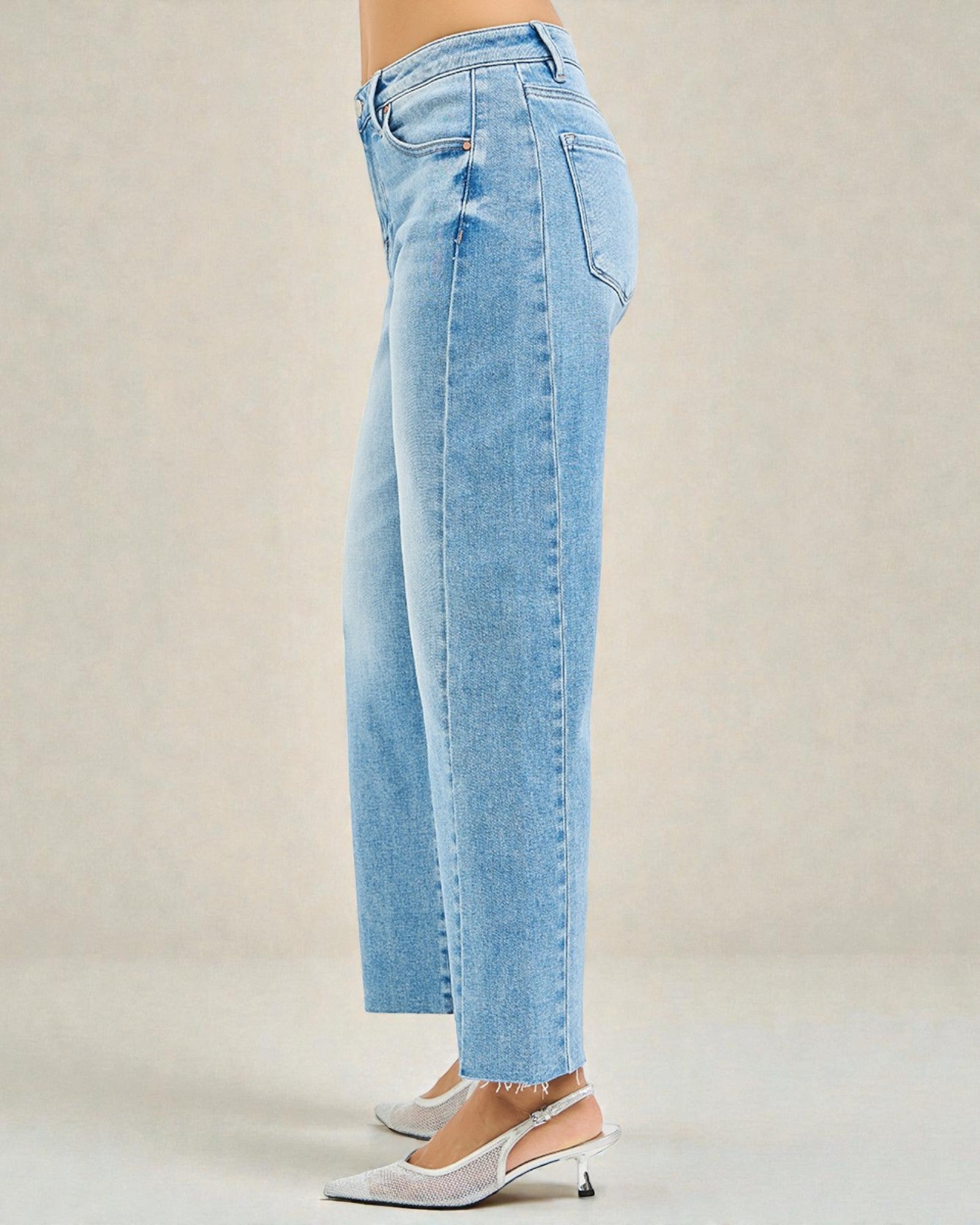 Light blue jeans worn by a person on a beige background