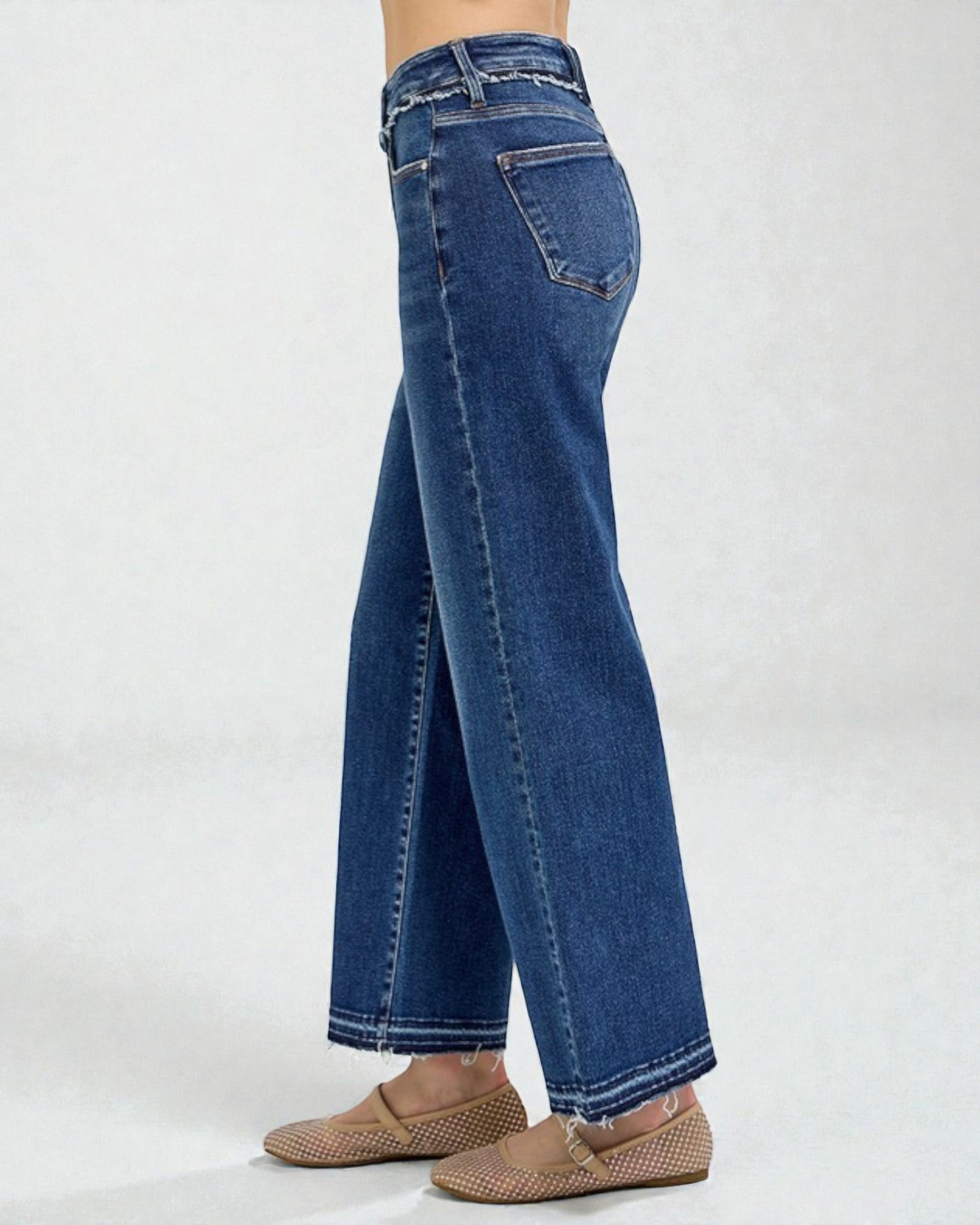 Blue jeans worn by a person on a white background