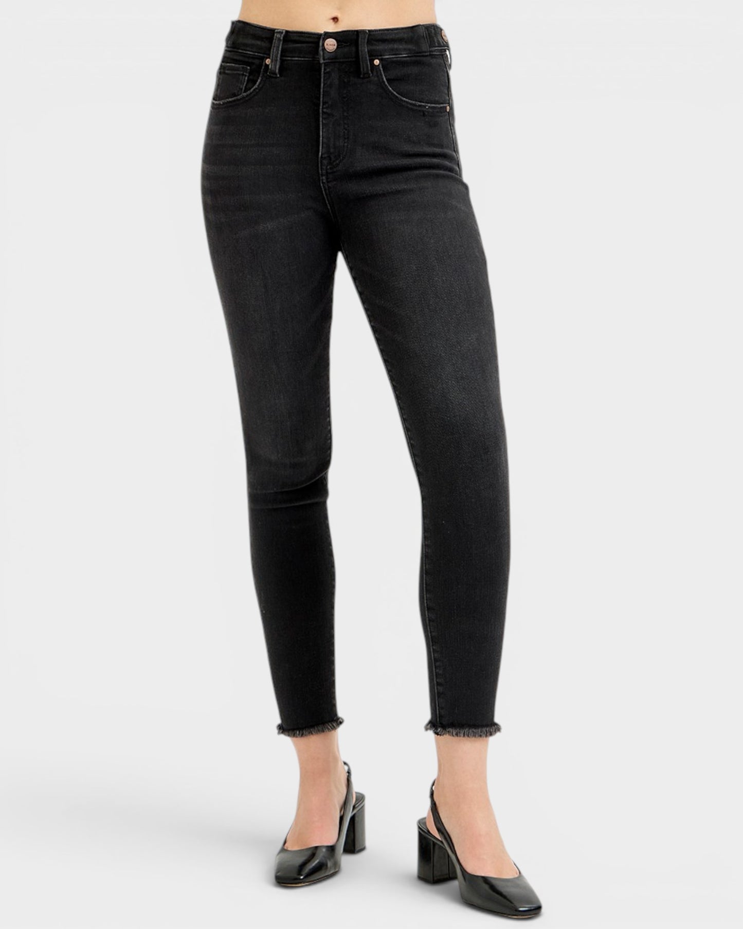 Black jeans worn by a person on a white background