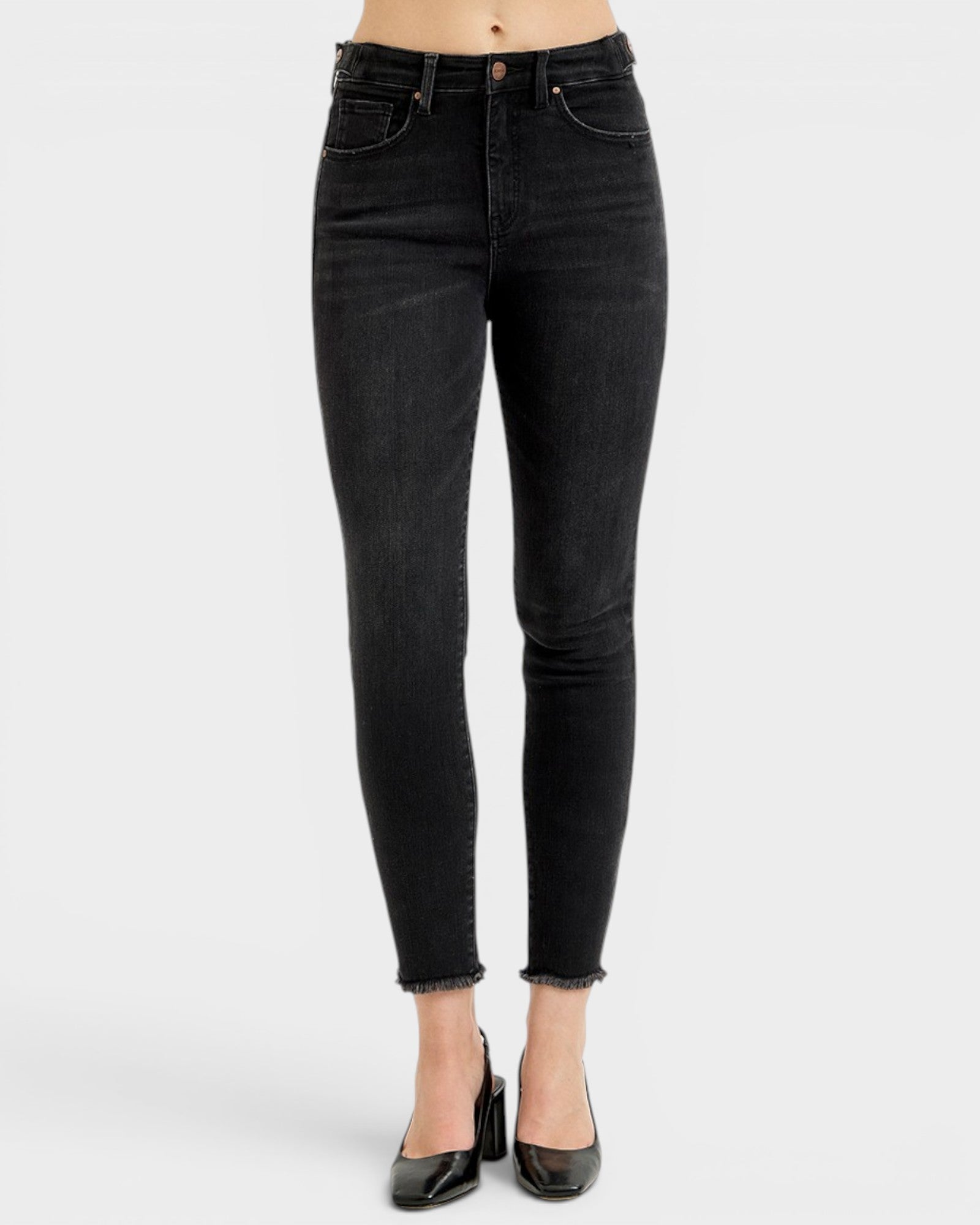 Black jeans worn by a person on a white background