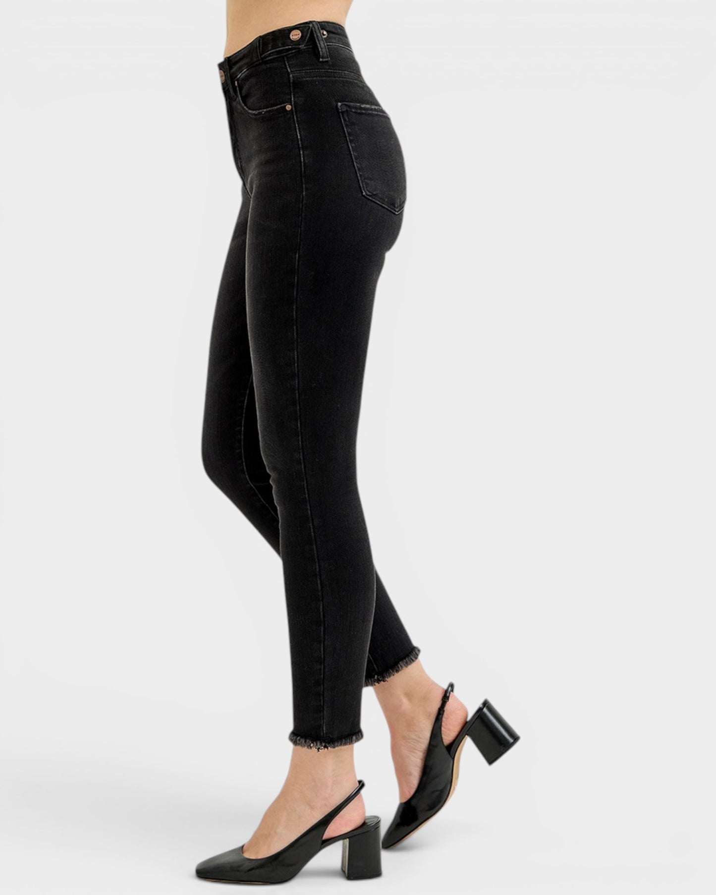 Black jeans worn by a person on a white background