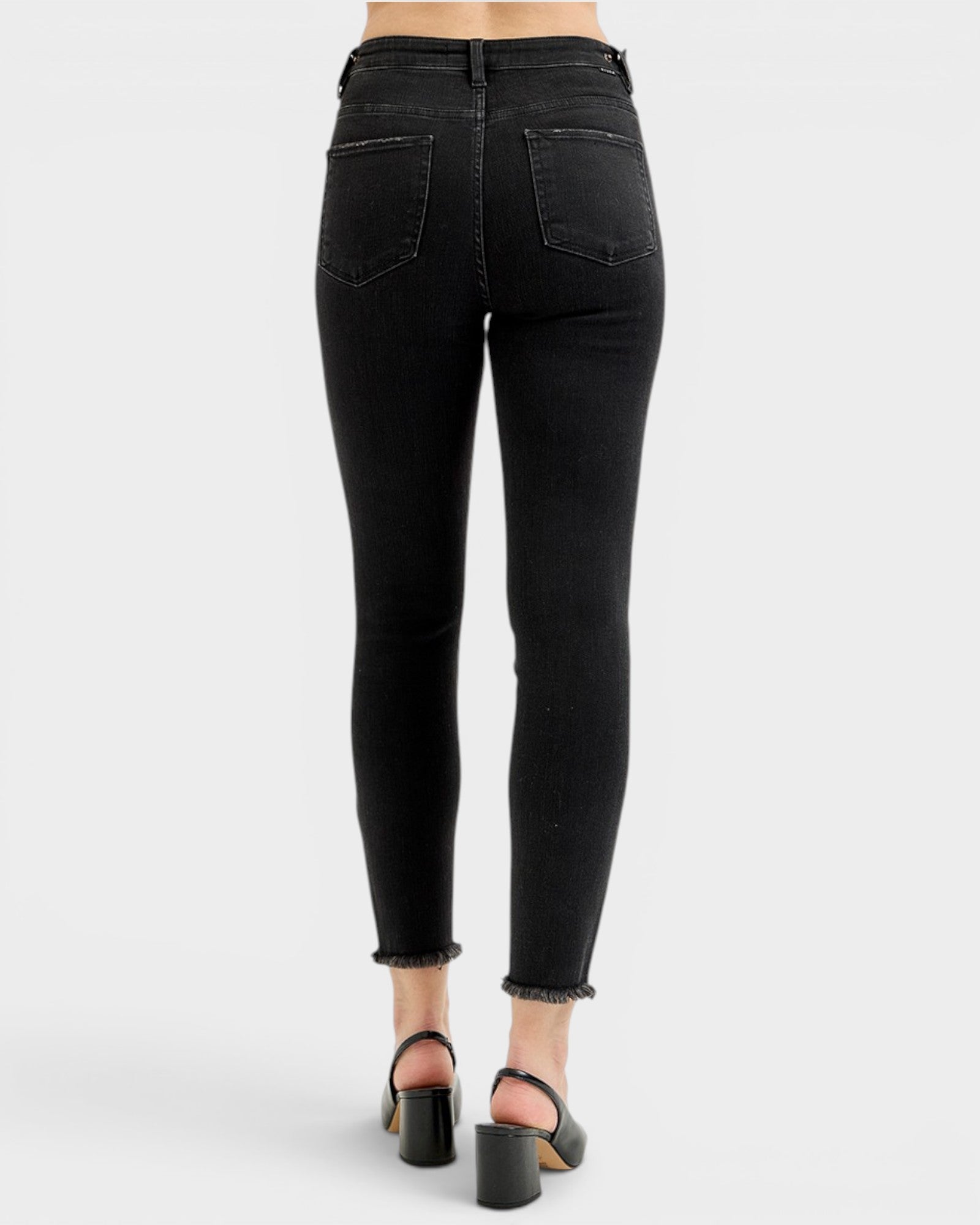 Black jeans worn by a person on a white background