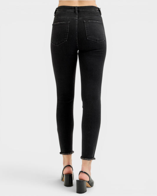 Black jeans worn by a person on a white background