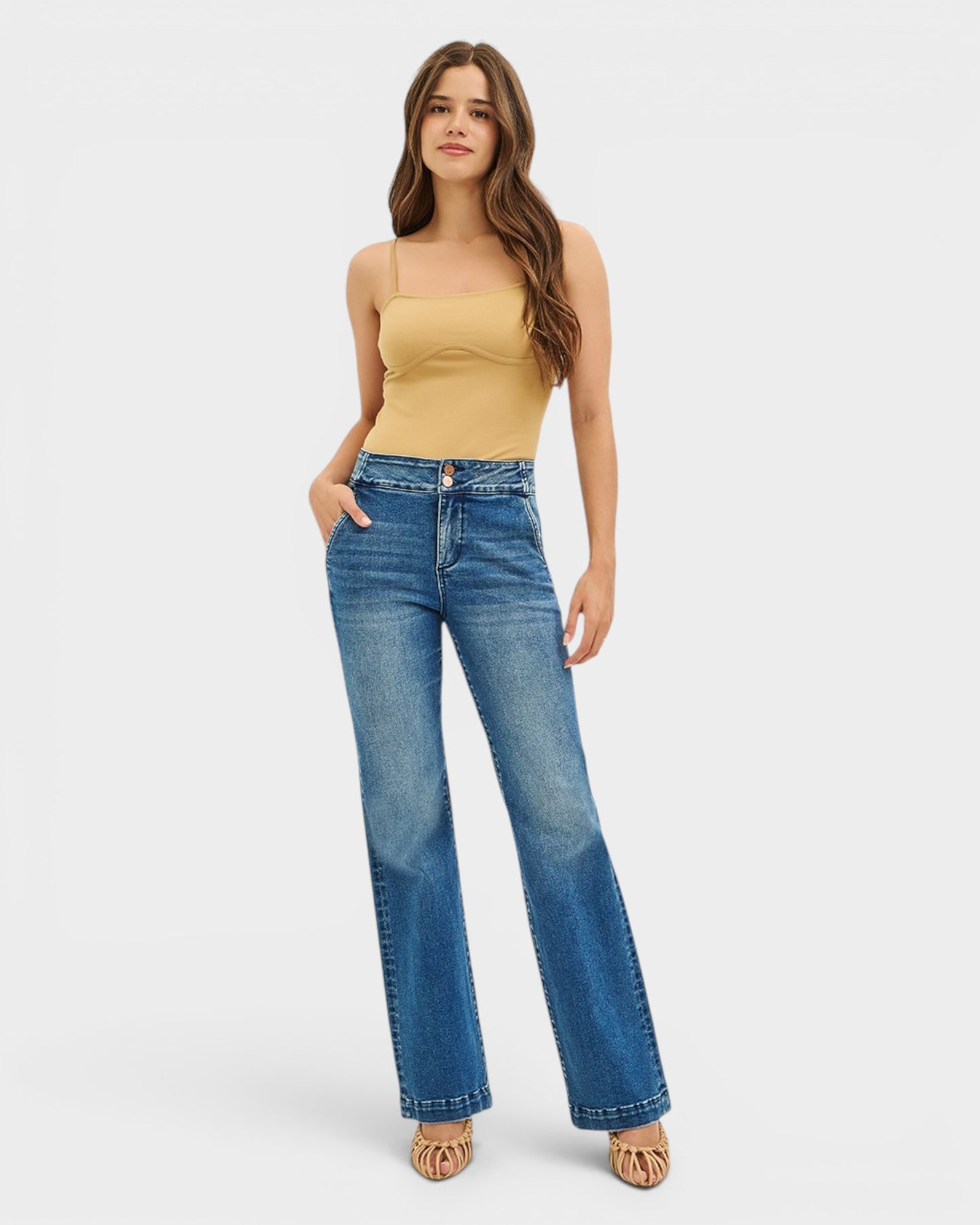 Woman wearing a yellow top and blue jeans on a white background
