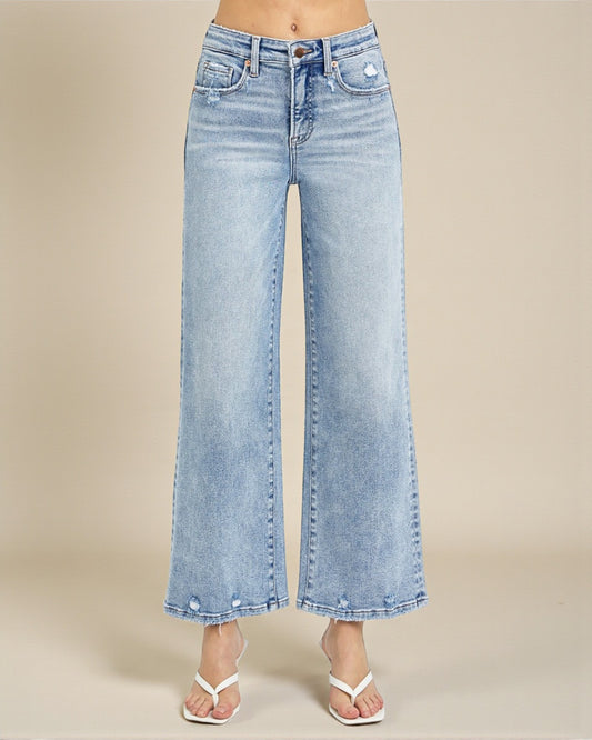 Light blue jeans worn by a person on a beige background