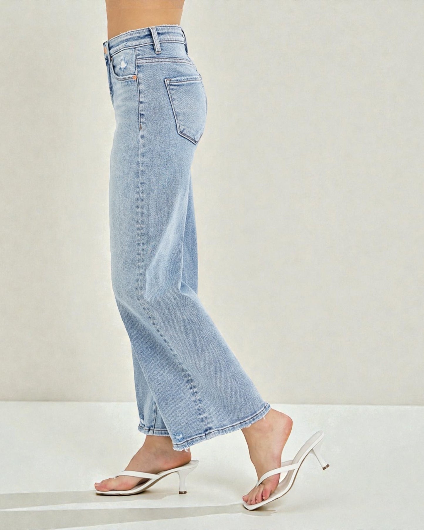 Light blue jeans worn by a person on a plain background