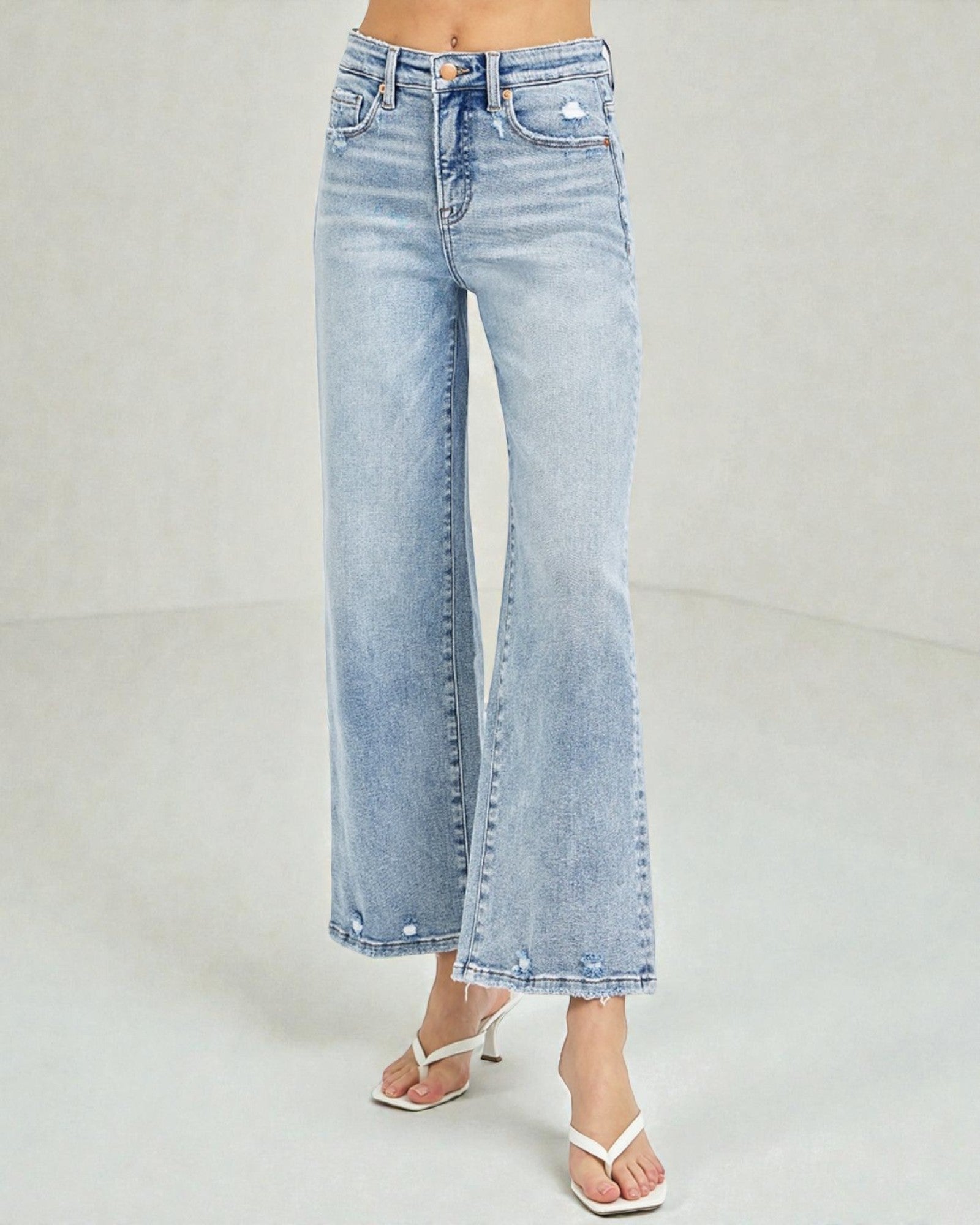 Light blue jeans worn by a person on a plain background