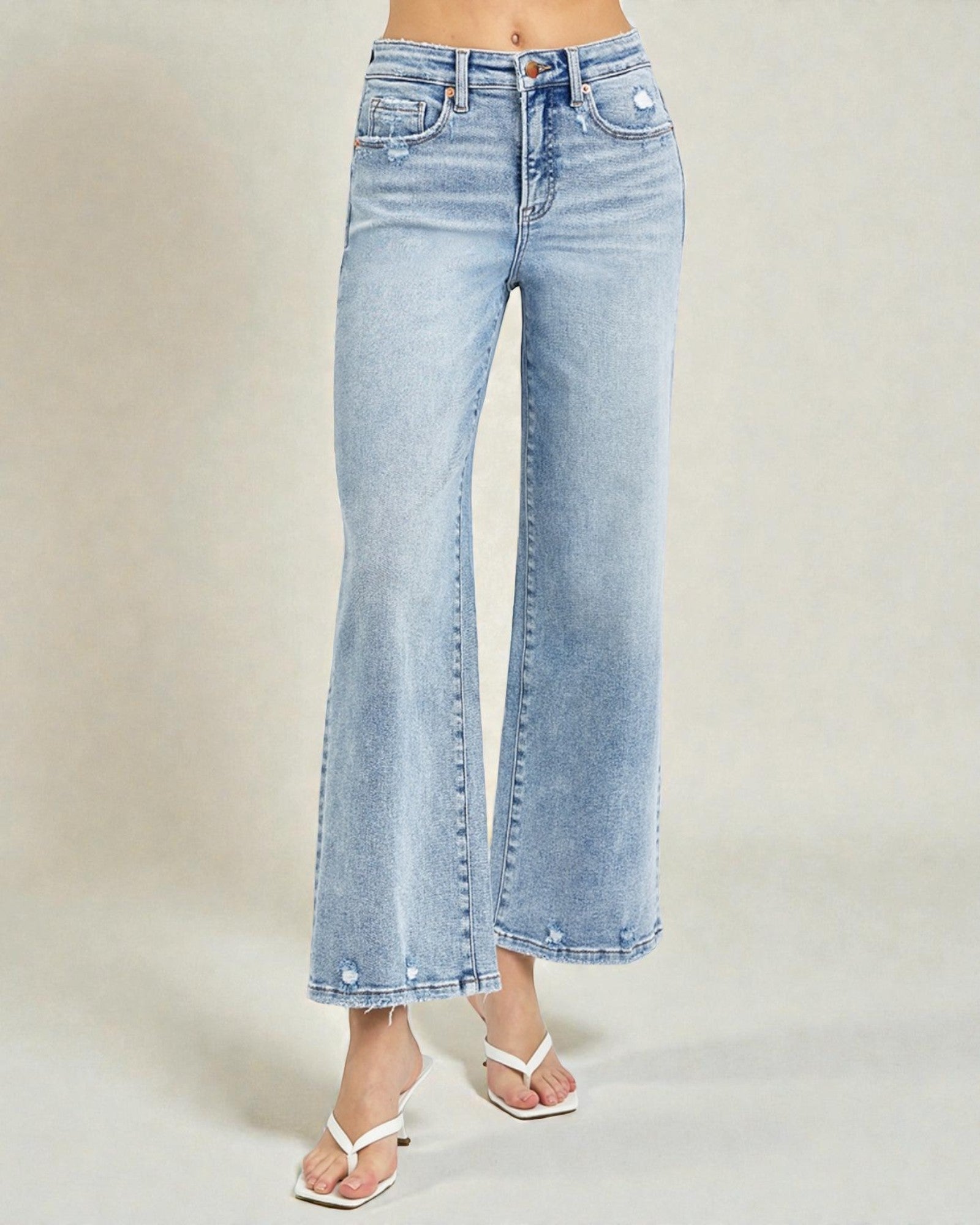 Light blue jeans worn by a person on a plain background