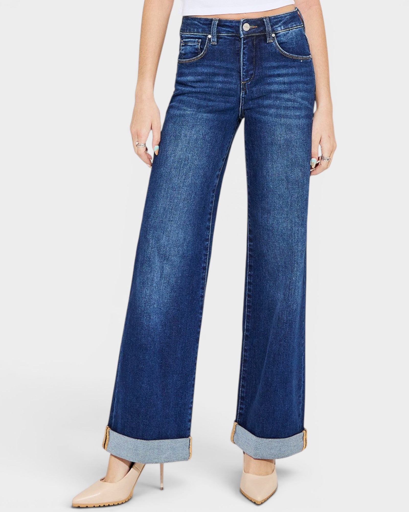 Blue jeans with rolled cuffs worn by a person on a white background