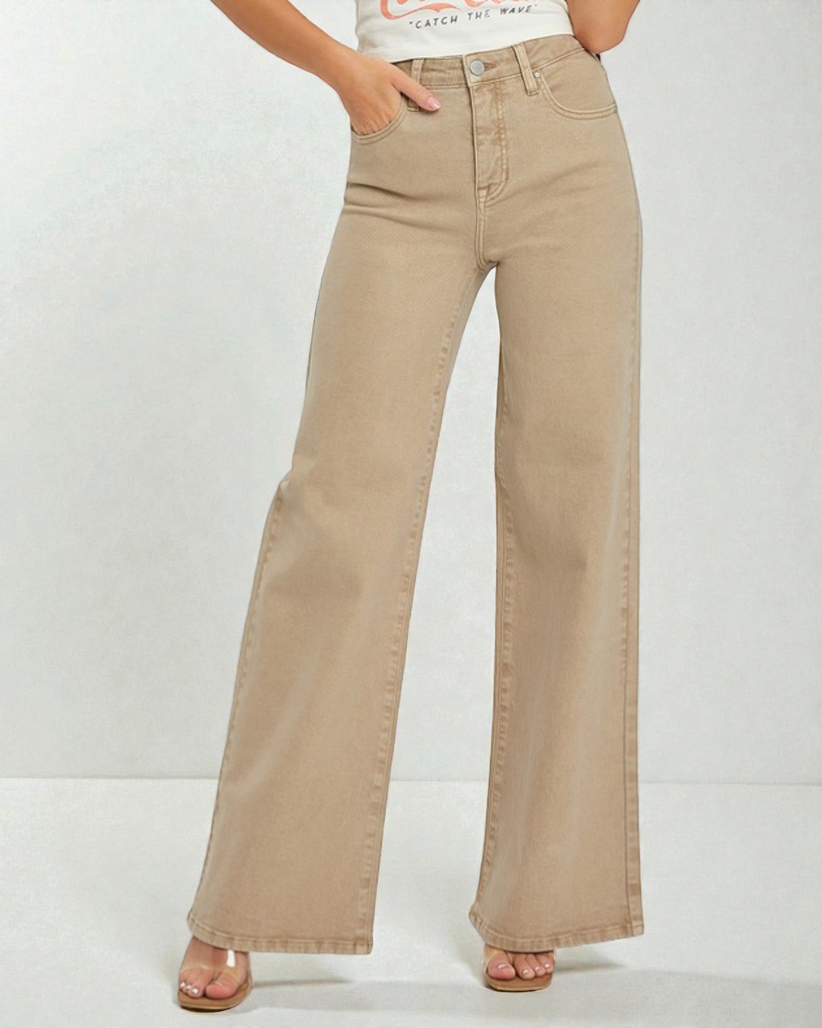 Beige wide-leg jeans worn by a person on a white background