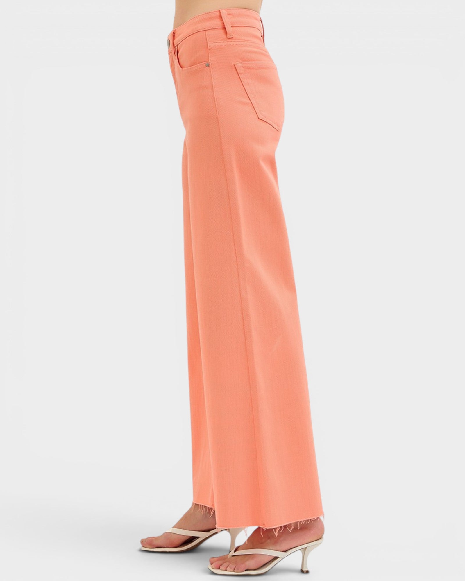 Coral pants worn by a person on a white background