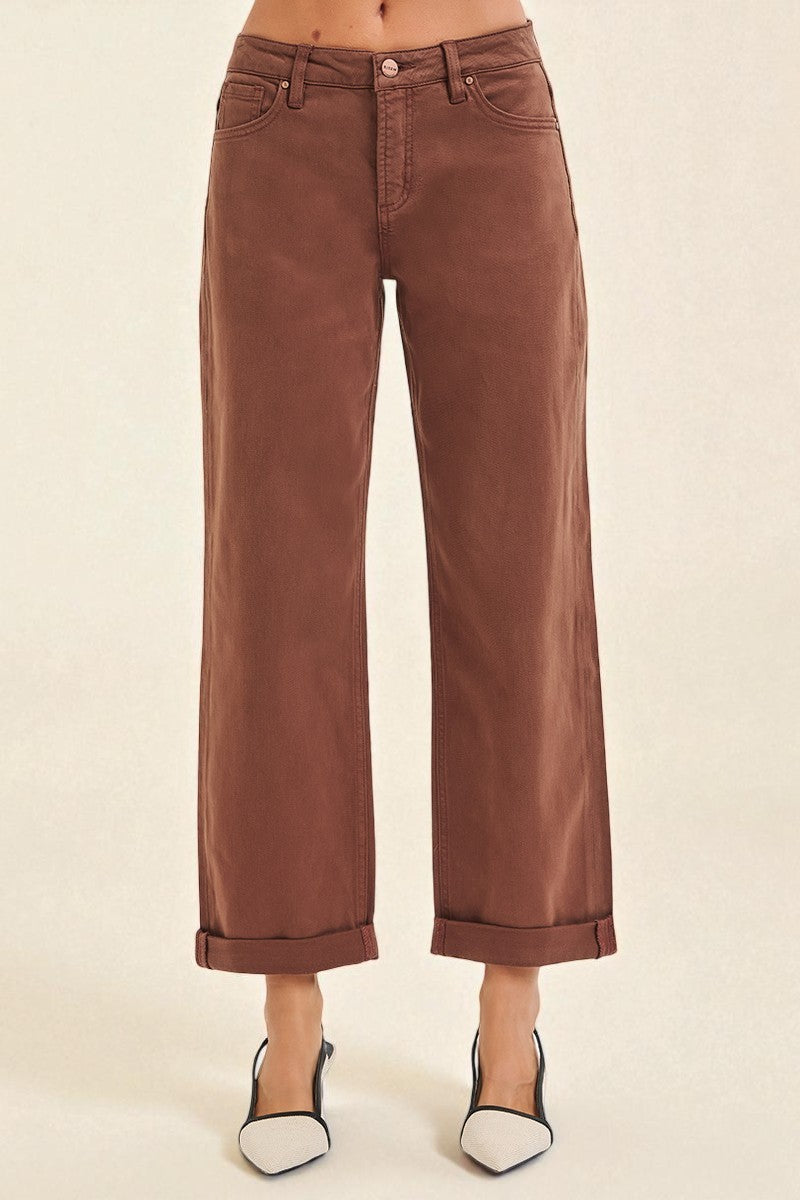 Brown wide-leg pants worn by a person on a beige background